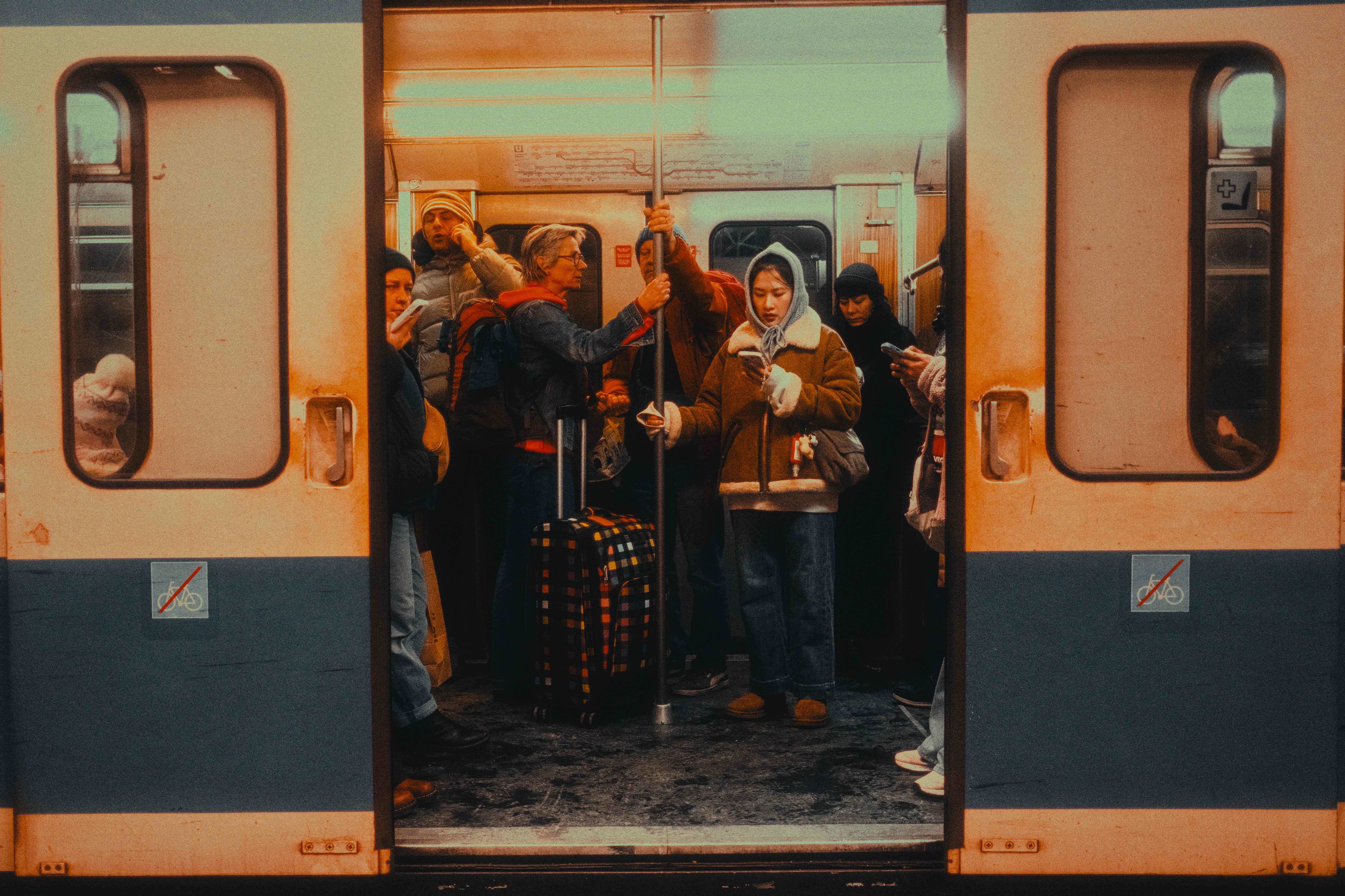 Symmetrical frame of a crowded U-Bahn car seen through the open doors