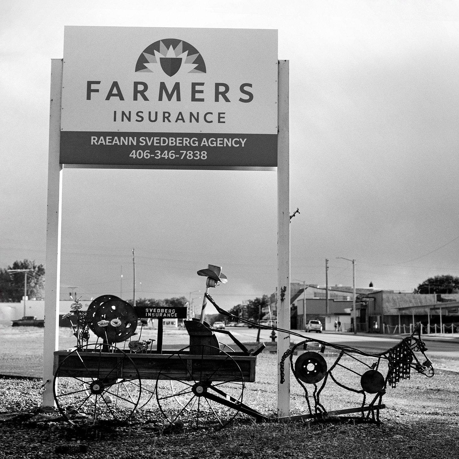 Farmers Insurance sign with whimsical metal horse and wagon sculpture made from farm equipment parts