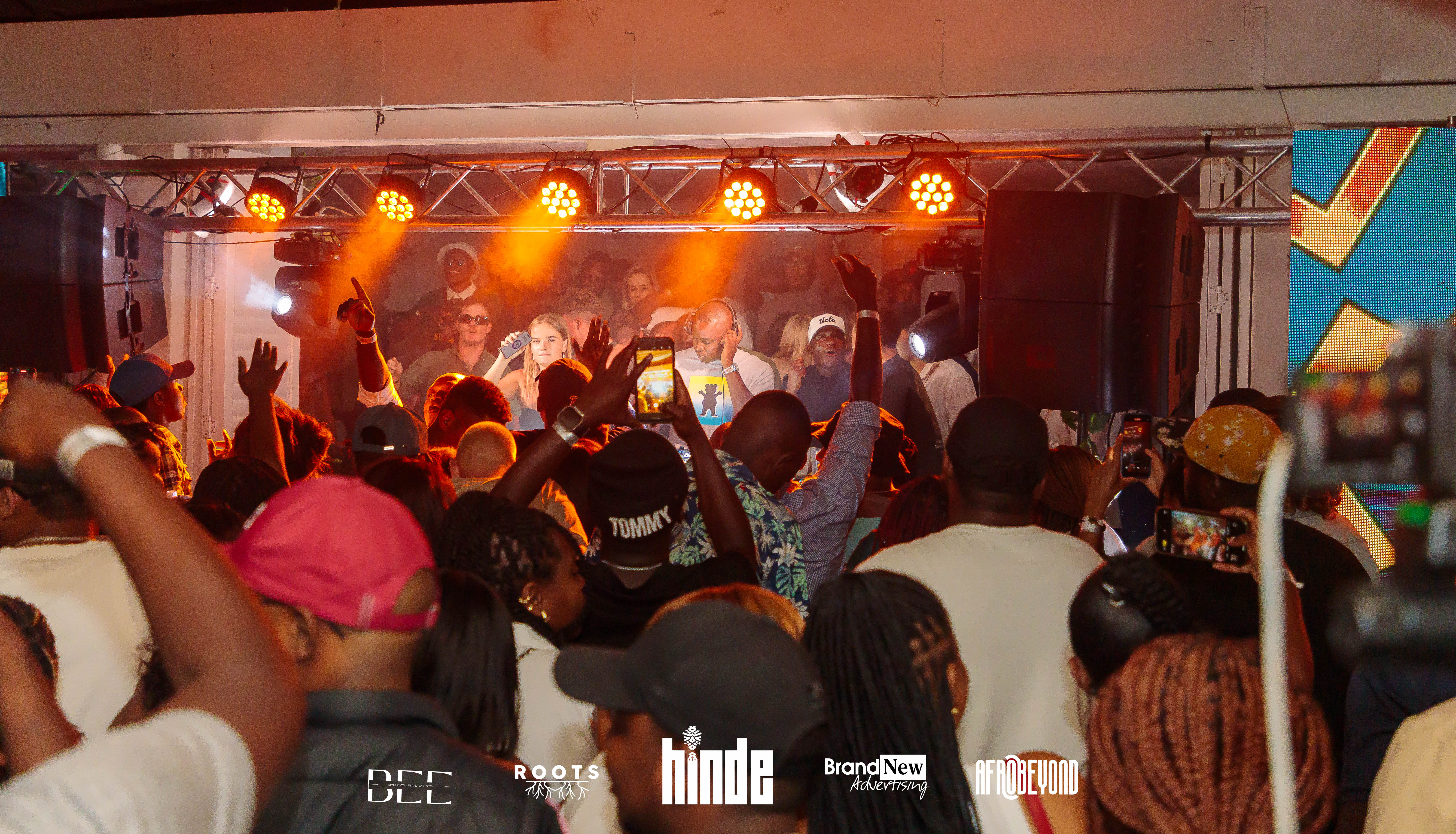 Concert with orange lighting and enthusiastic crowd