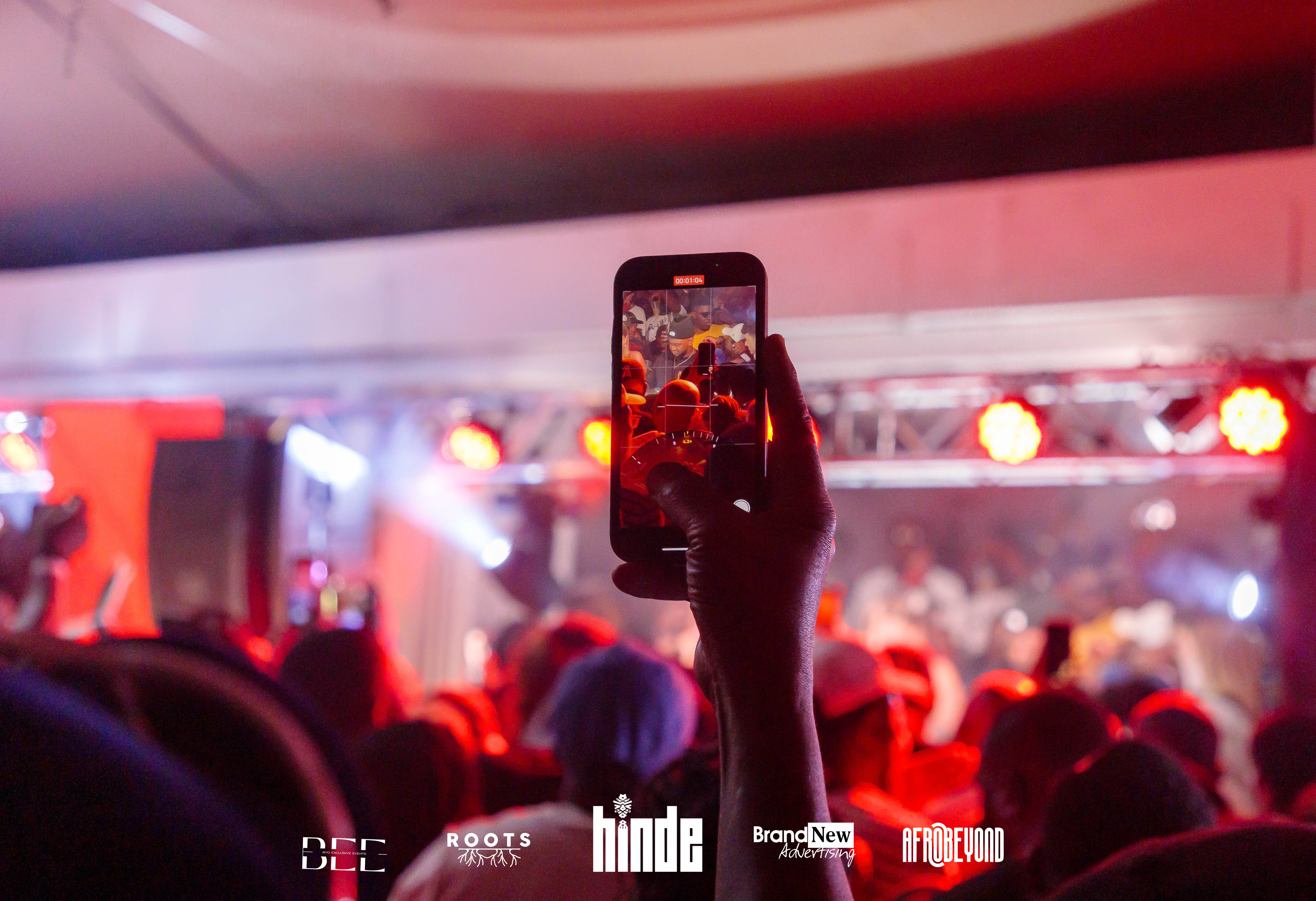 Concert recording on phone with red stage lighting