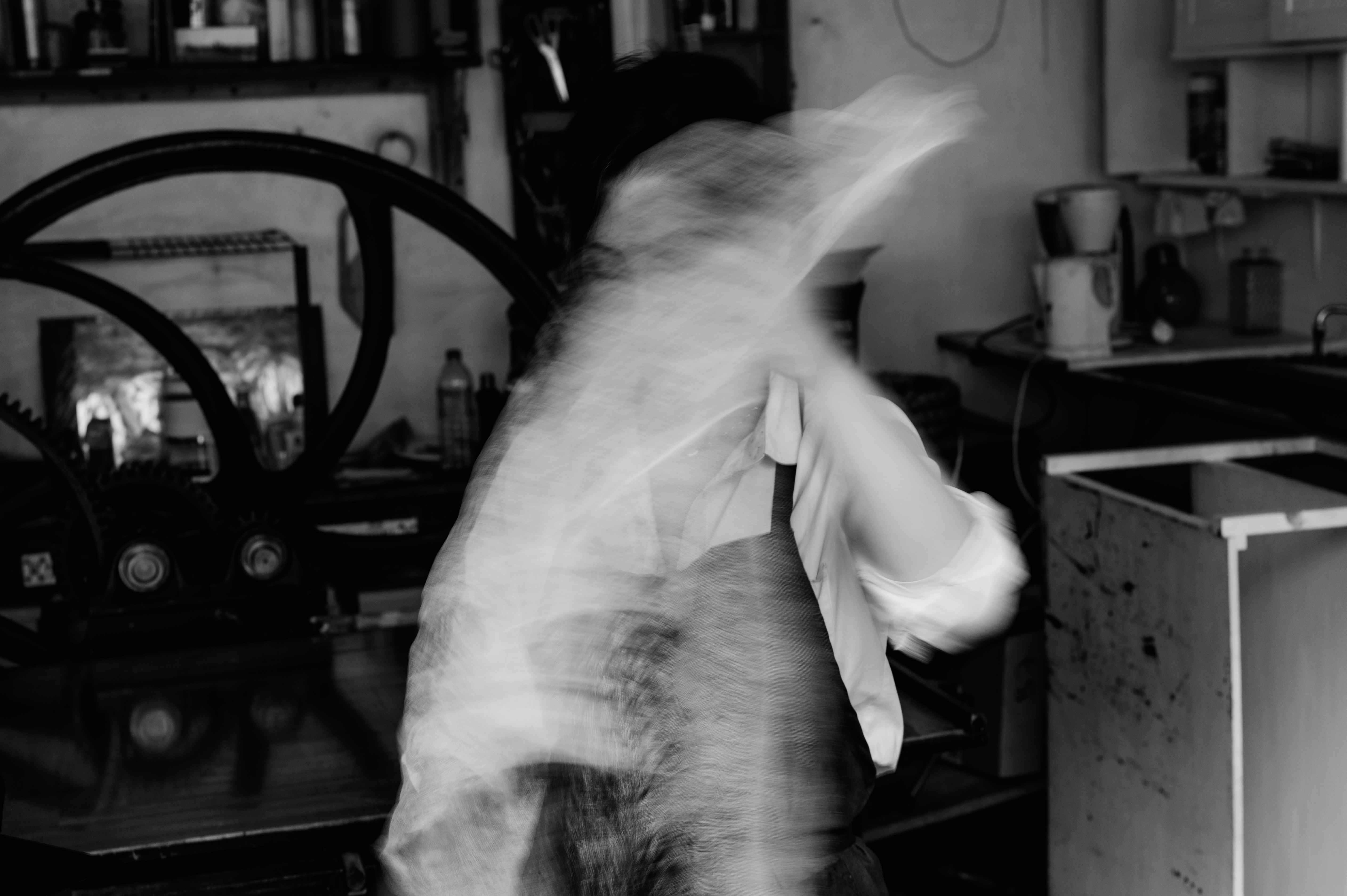 Long-exposure motion of the artist working in the atelier.