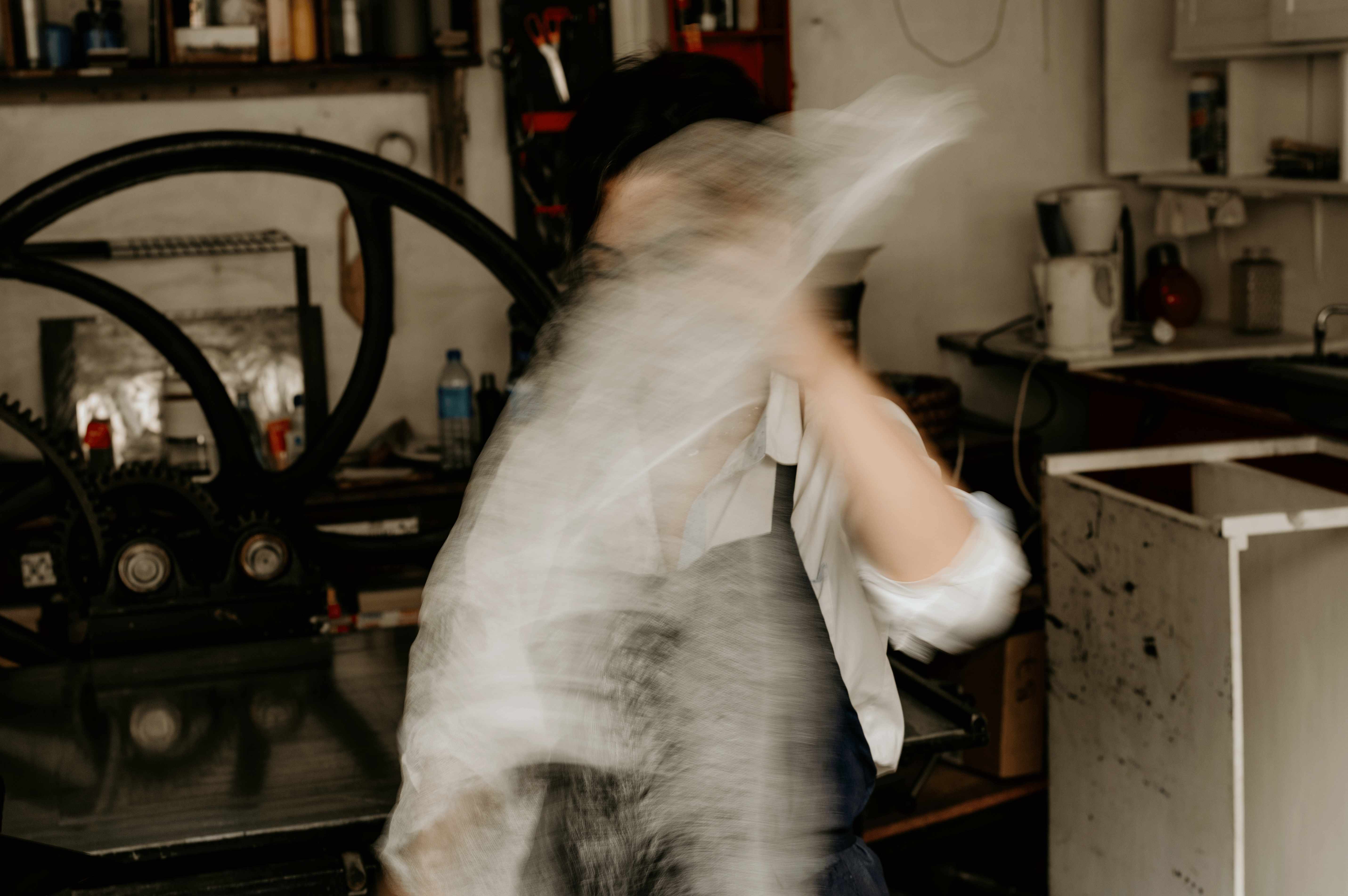 Long-exposure motion of the artist working in the atelier.