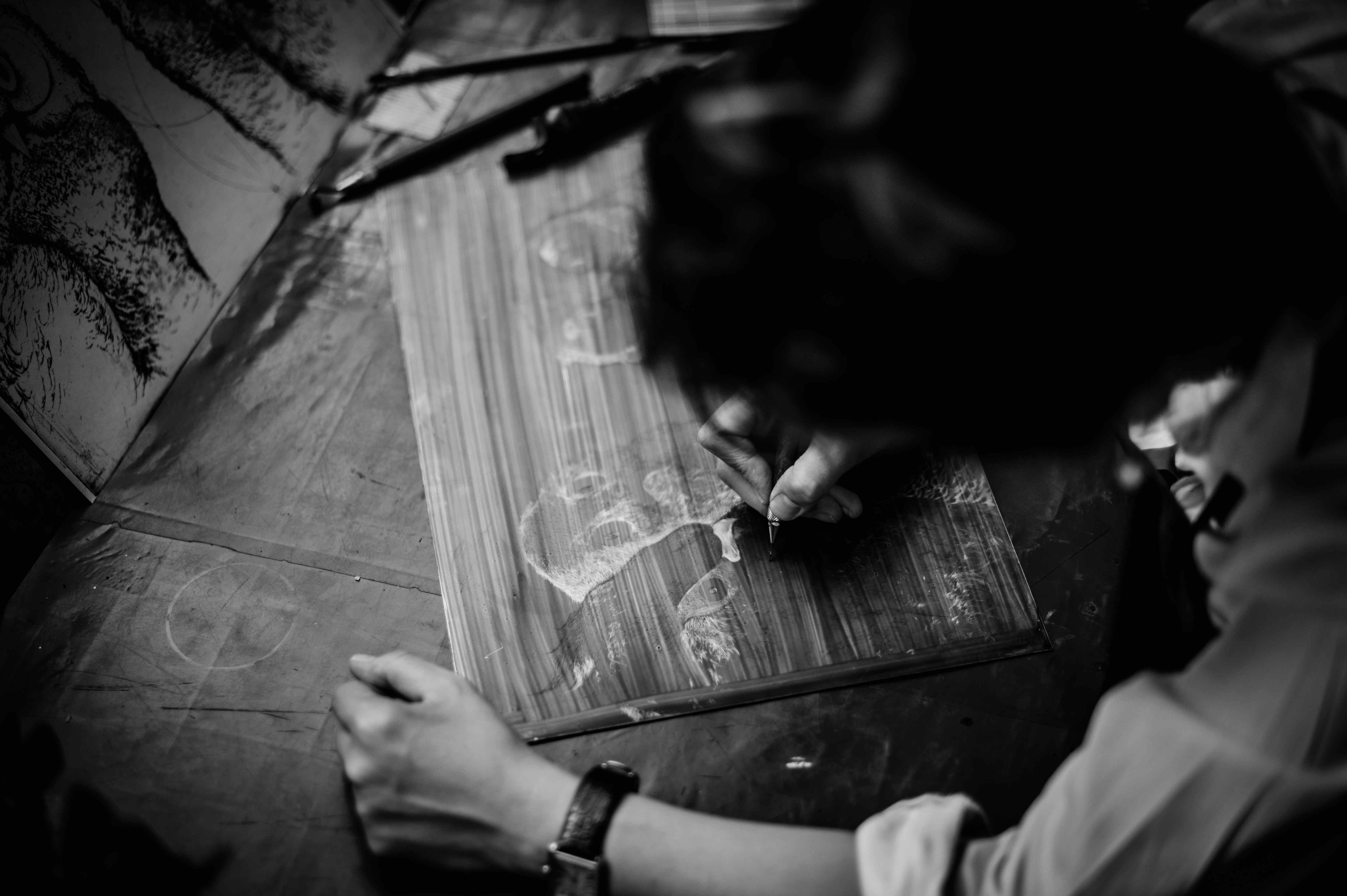 Engraving fine lines into a copper plate with a drypoint needle.