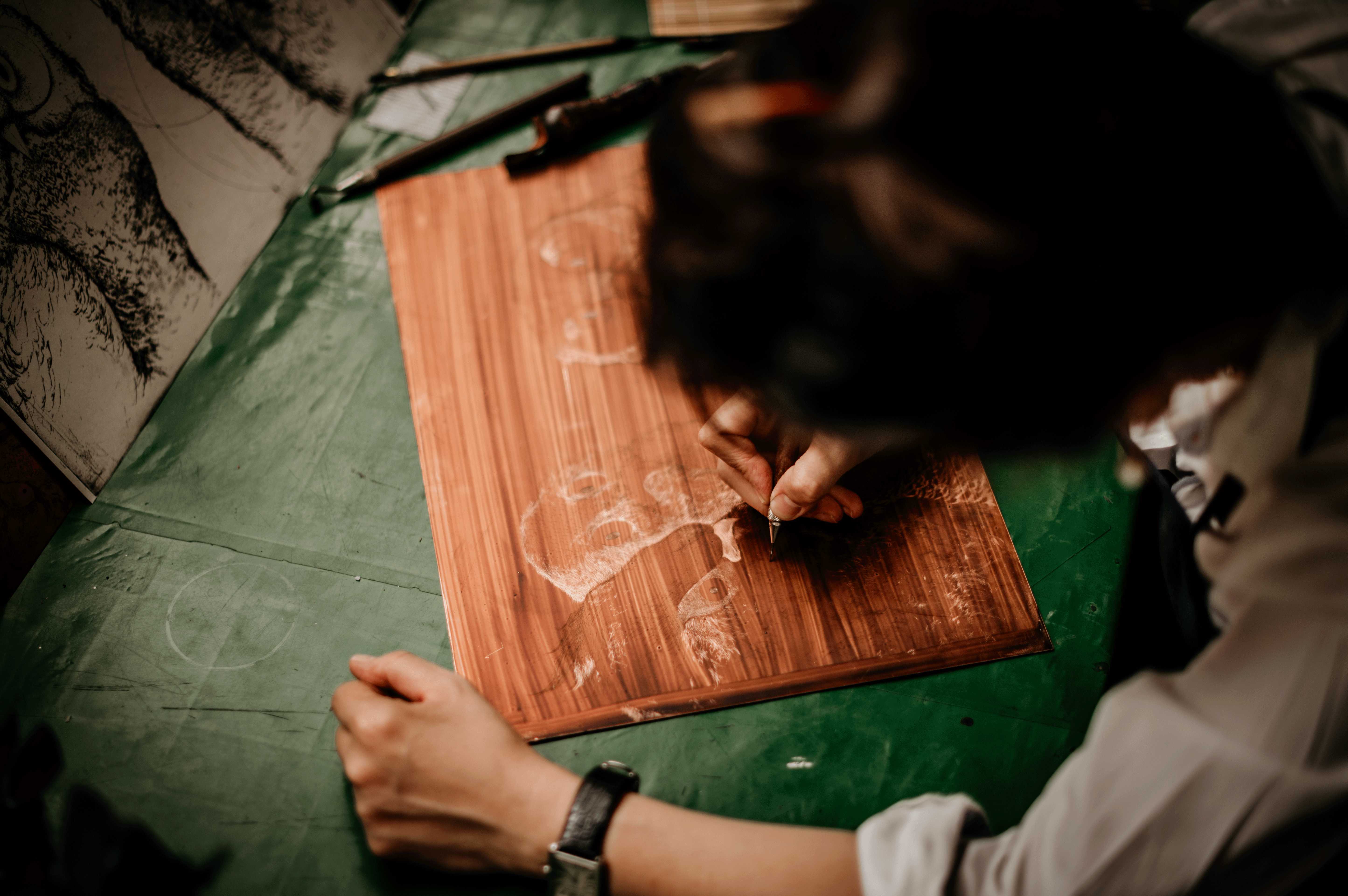 Engraving fine lines into a copper plate with a drypoint needle.
