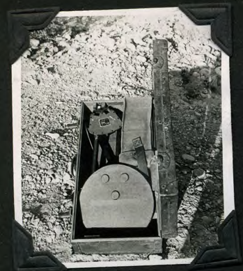 A mine detector and measuring stick laid out on the ground.