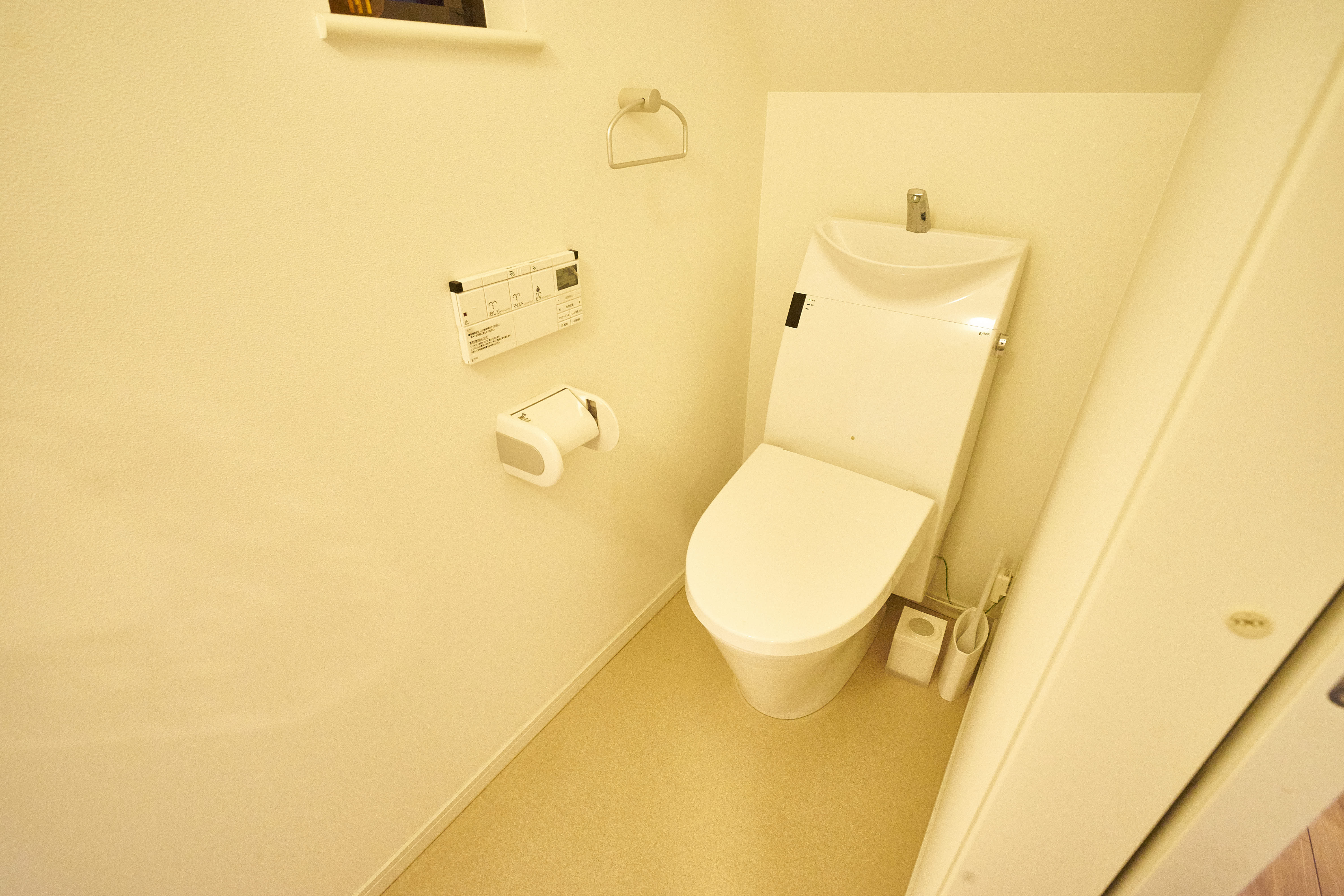 Clean modern 1F toilet with Japanese high-tech fixtures and integrated sink
