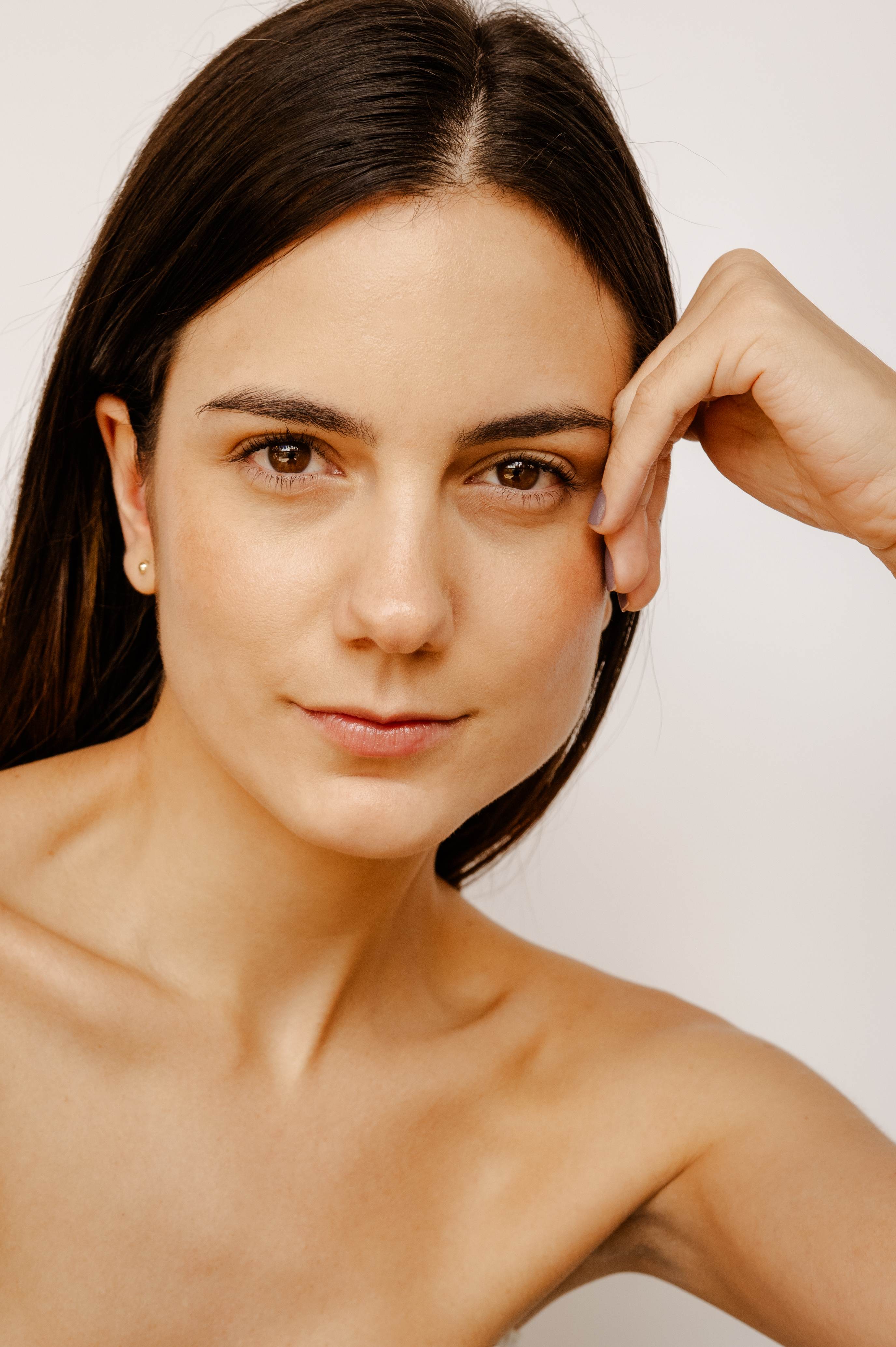 Paciente de Clínica Ohmio con piel luminosa y natural — retrato editorial de resultado médico estético