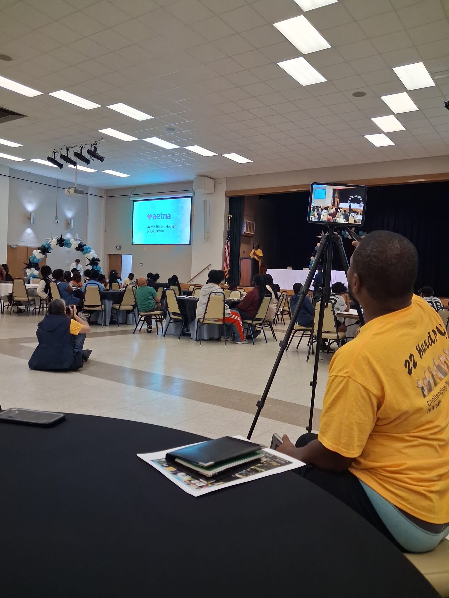 Youth and families seated at tables during the IRL Experience presentation