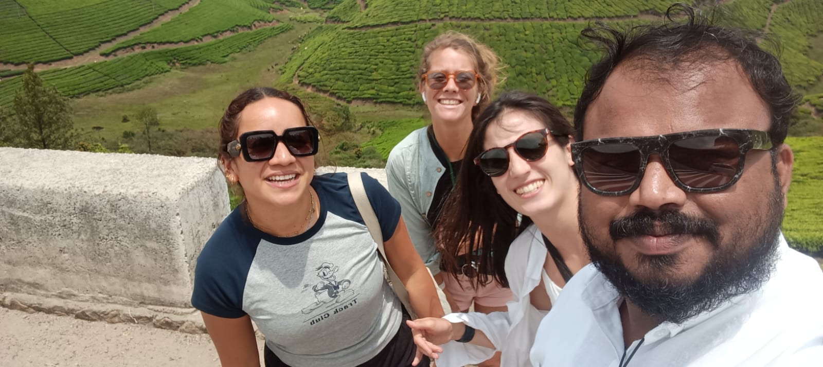 Happy travelers with Thanseer at Munnar tea plantations
