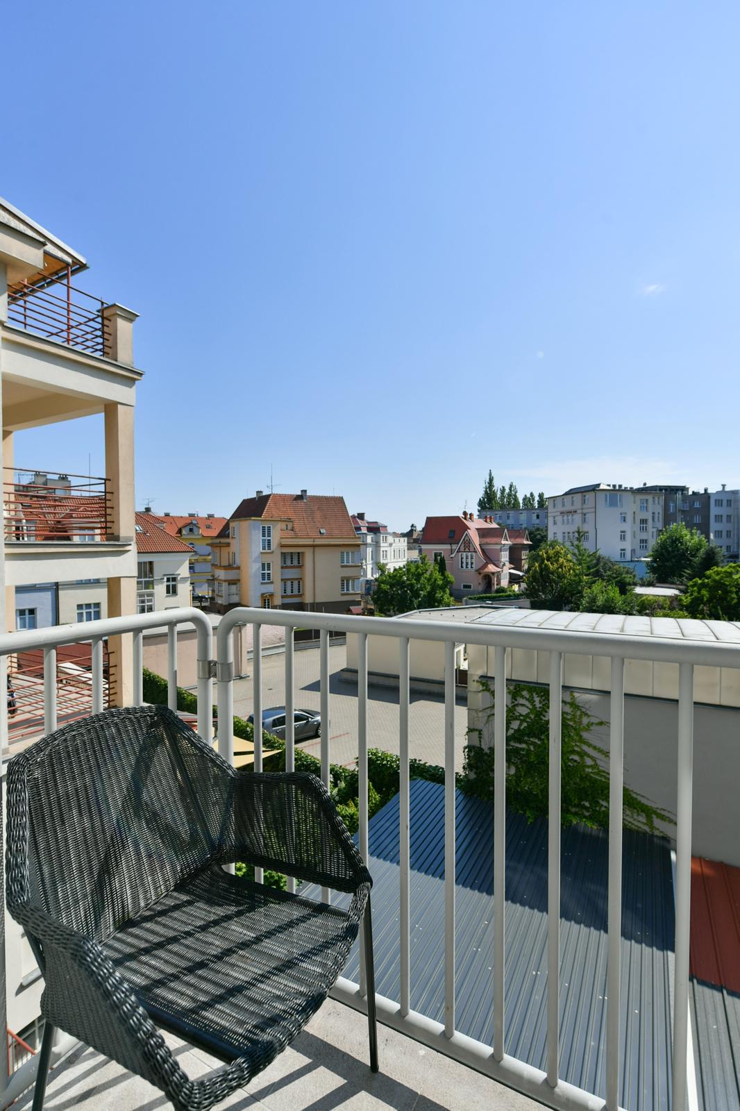 Balkon s ratanovým křeslem