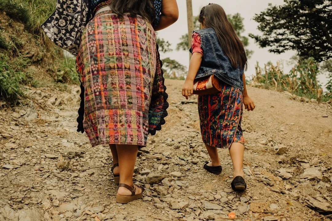 A mother and daughter walking a mountain path together