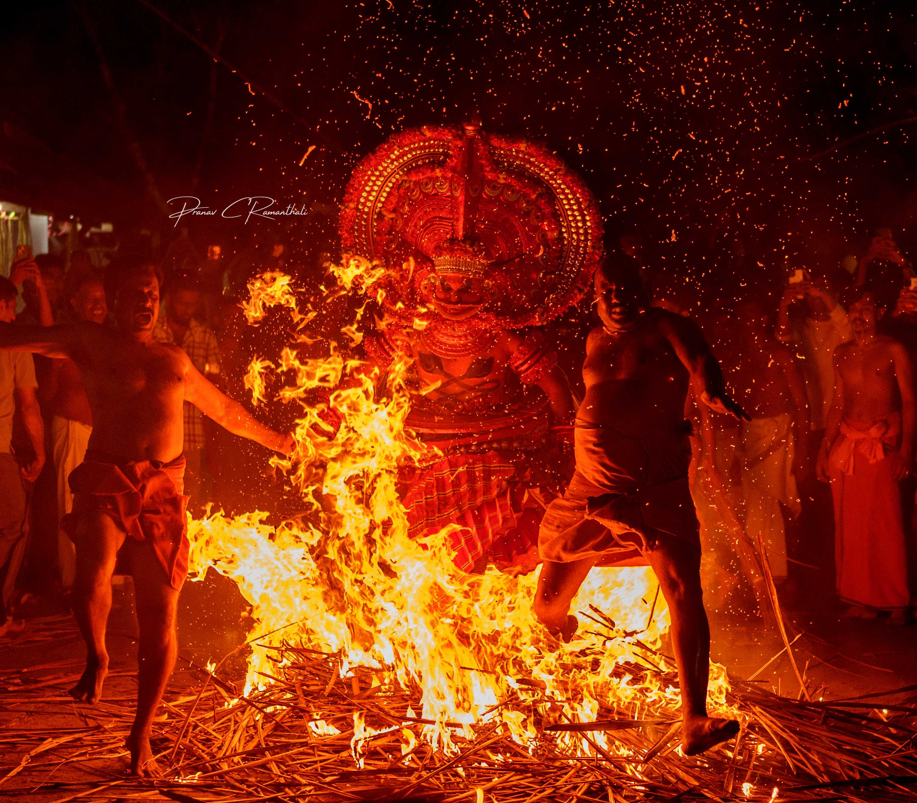 Theyyam fire ritual at night with sparks flying