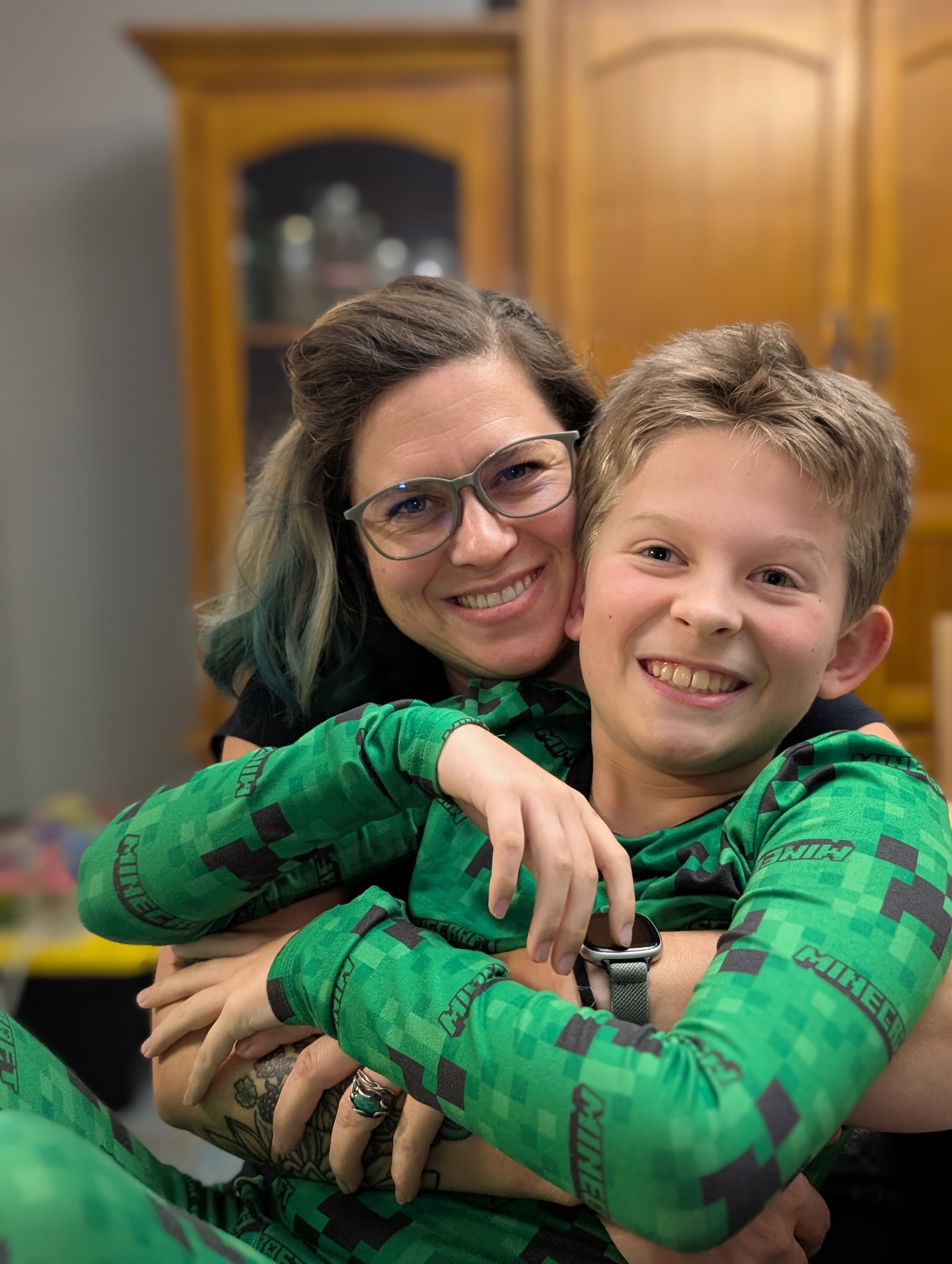 Rae sharing a warm hug with a child in matching pajamas