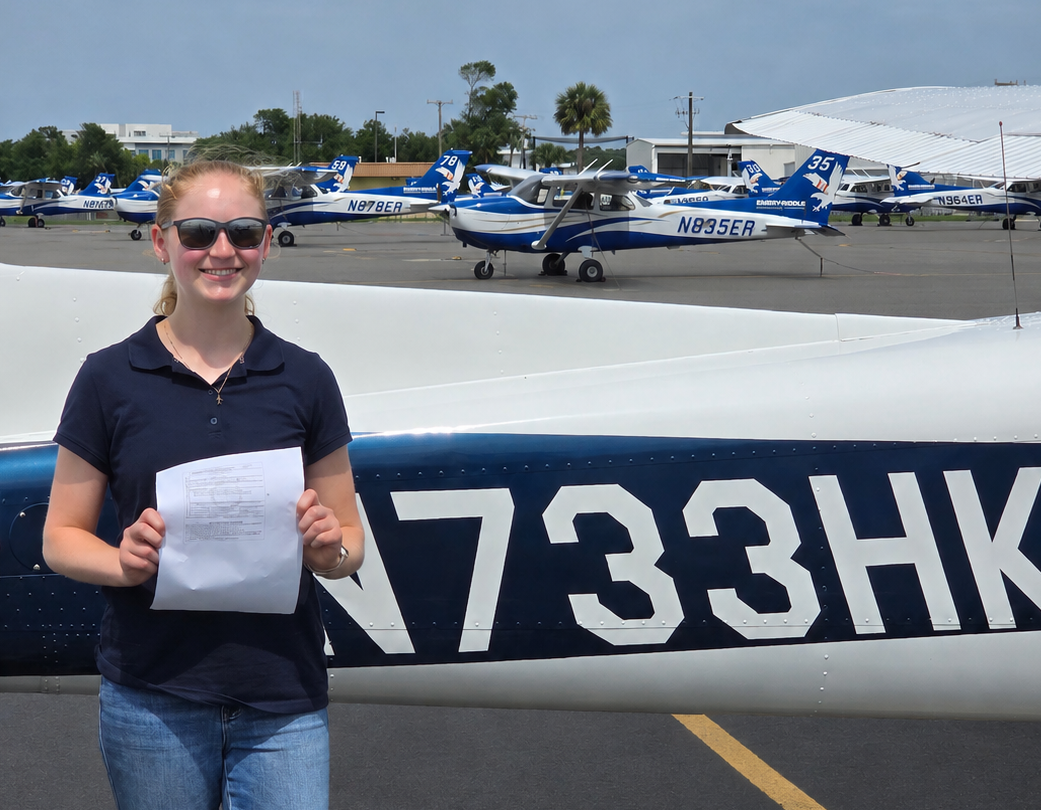 Female student holding temporary pilot certificate after successful checkride