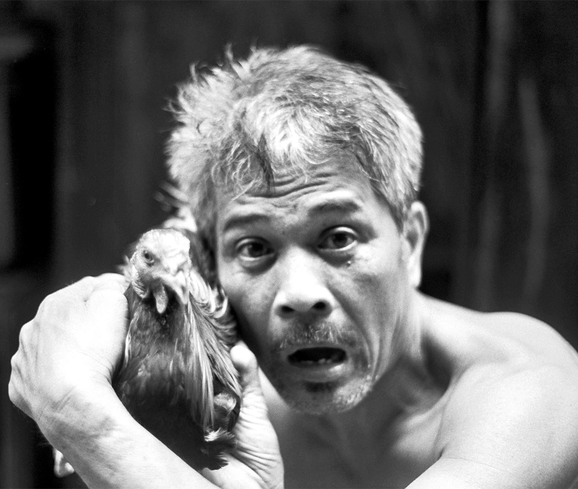 Man with animated expression holding small monkey animal
