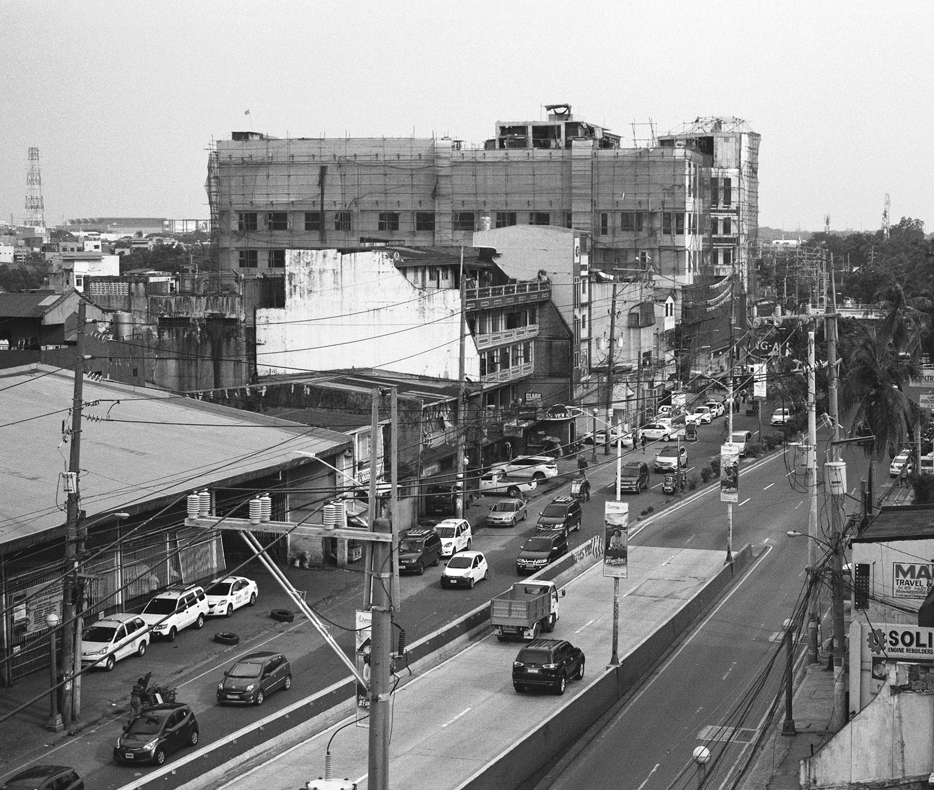 Black and white aerial view busy urban street with heavy traffic cars buses and commercial signage