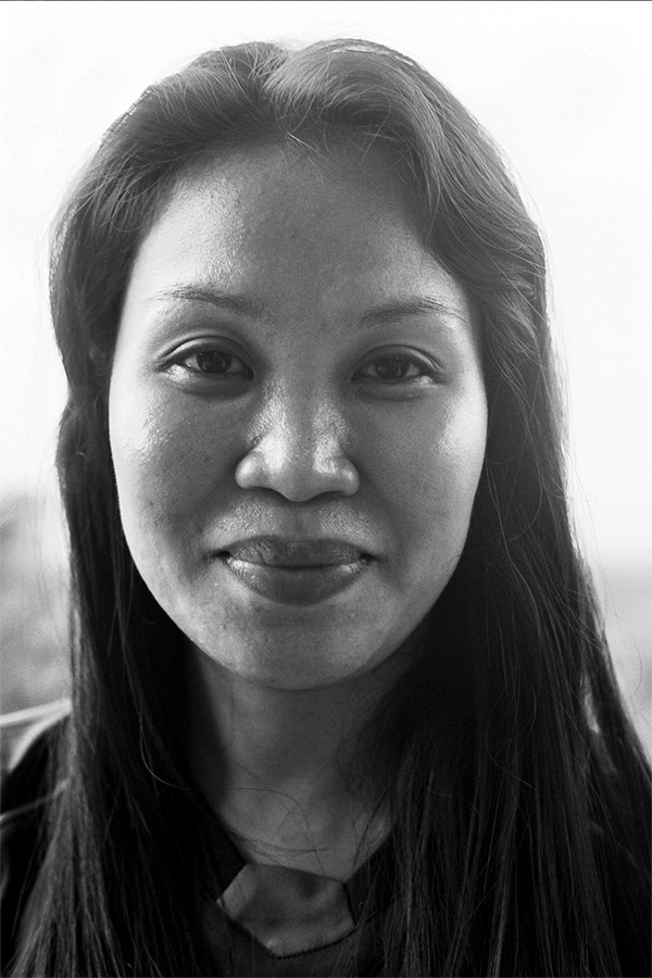 Black and white portrait of young woman with long dark hair smiling at camera