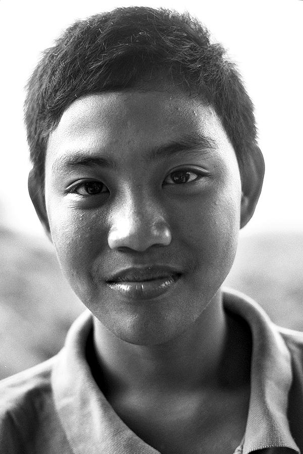 Black and white portrait of young man with short dark hair looking at camera