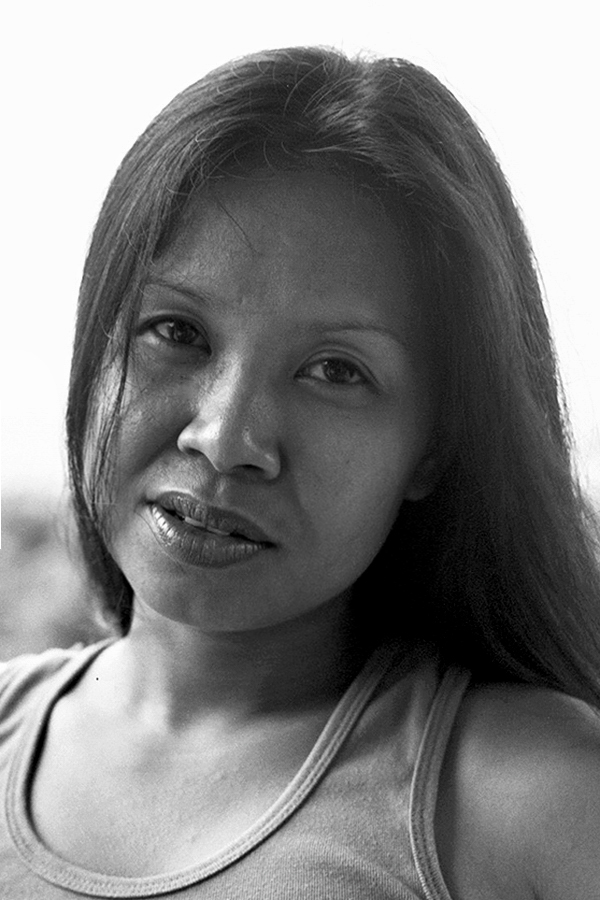 Black and white close-up portrait of woman with long dark hair wearing tank top