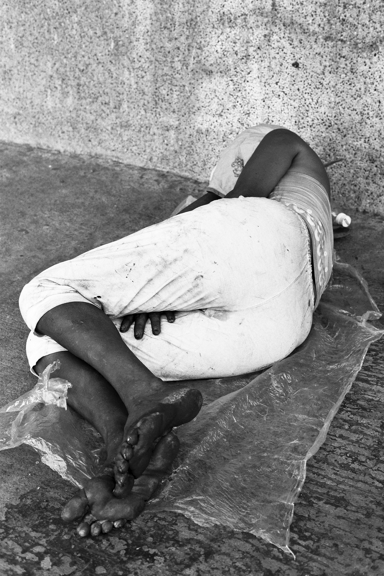 Black and white detail of wrapped rope and fabric with hands and feet