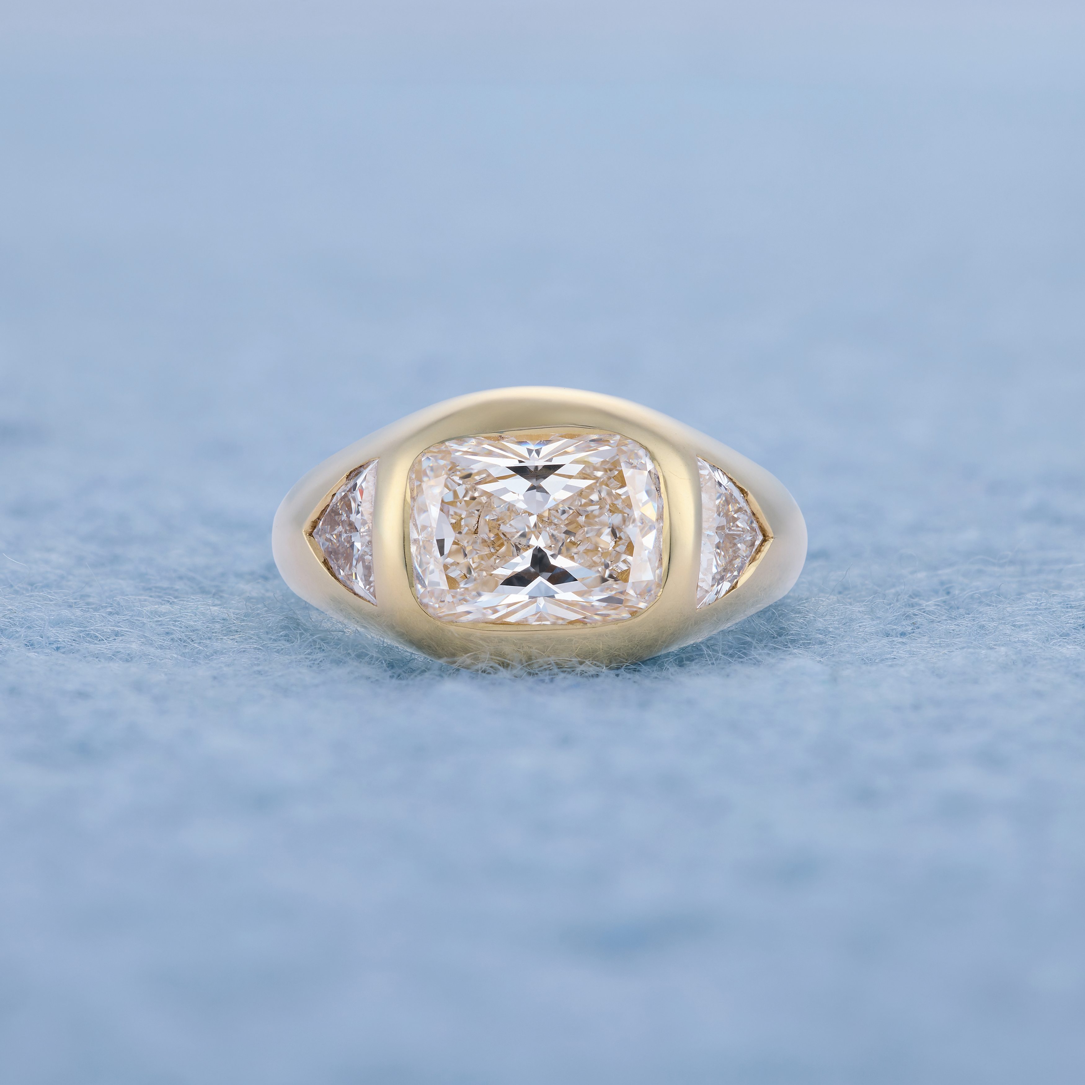 Cushion cut with trillion shoulders, lying flat blue background