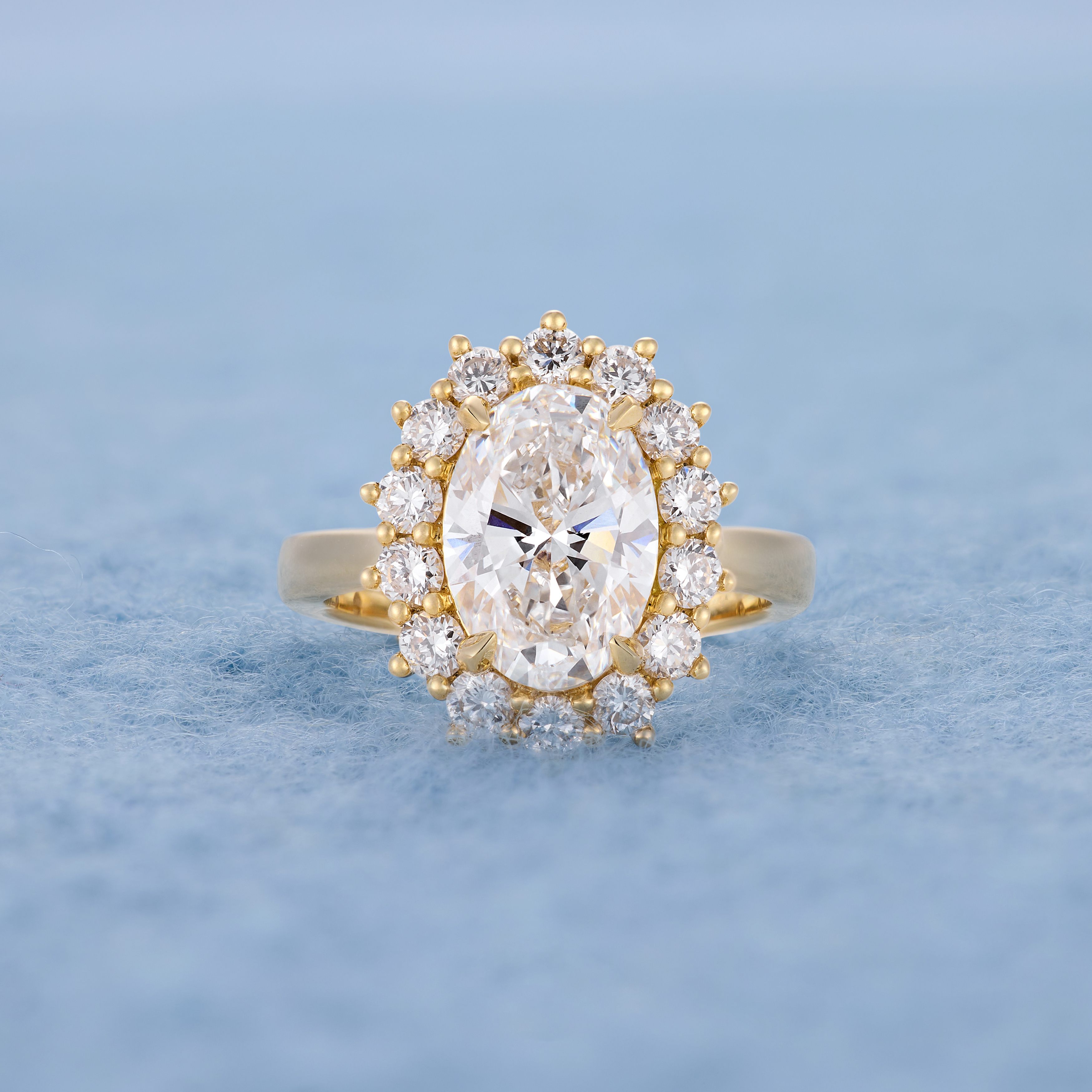 Oval diamond with star halo, lying flat blue background