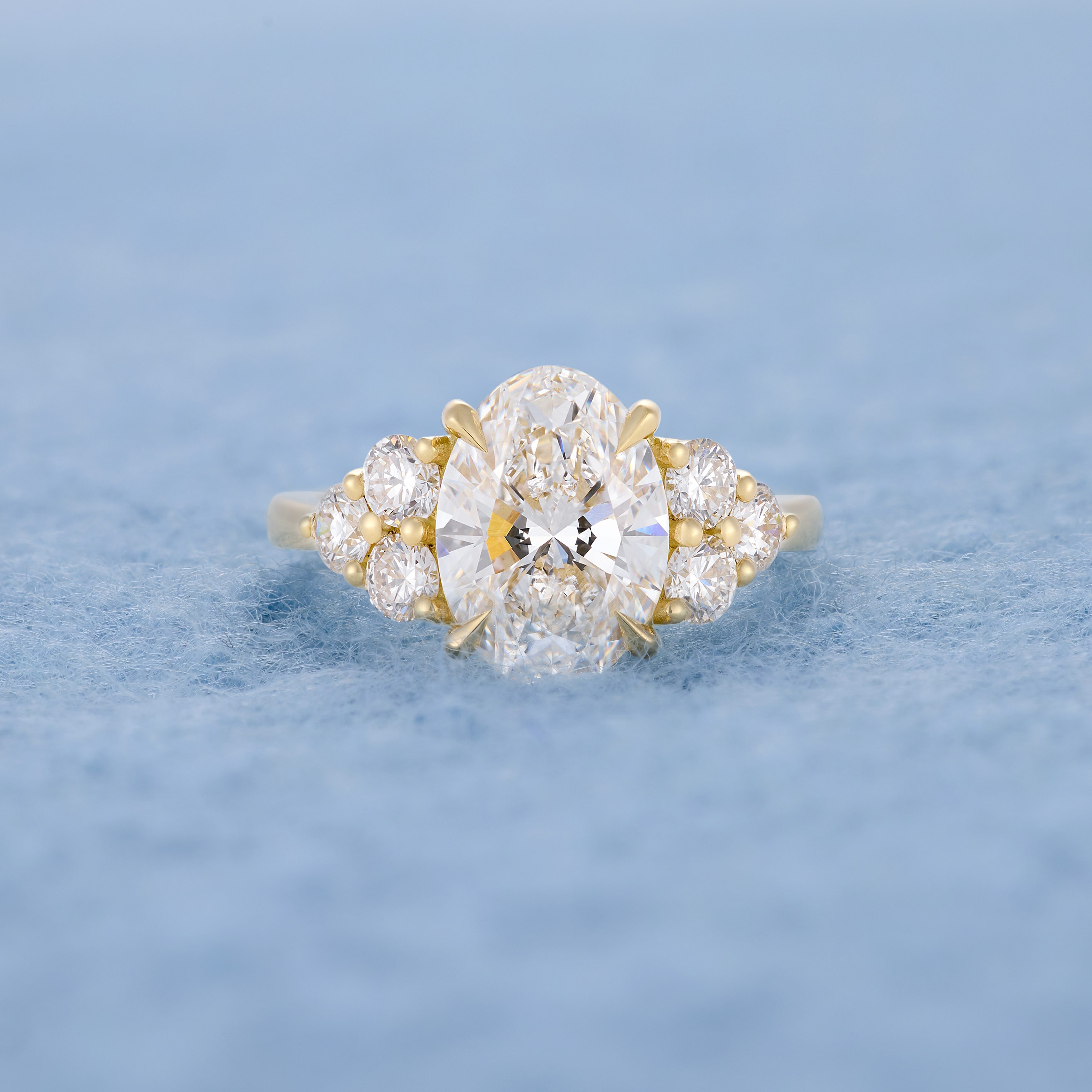 Oval with six round diamonds, lying flat blue background