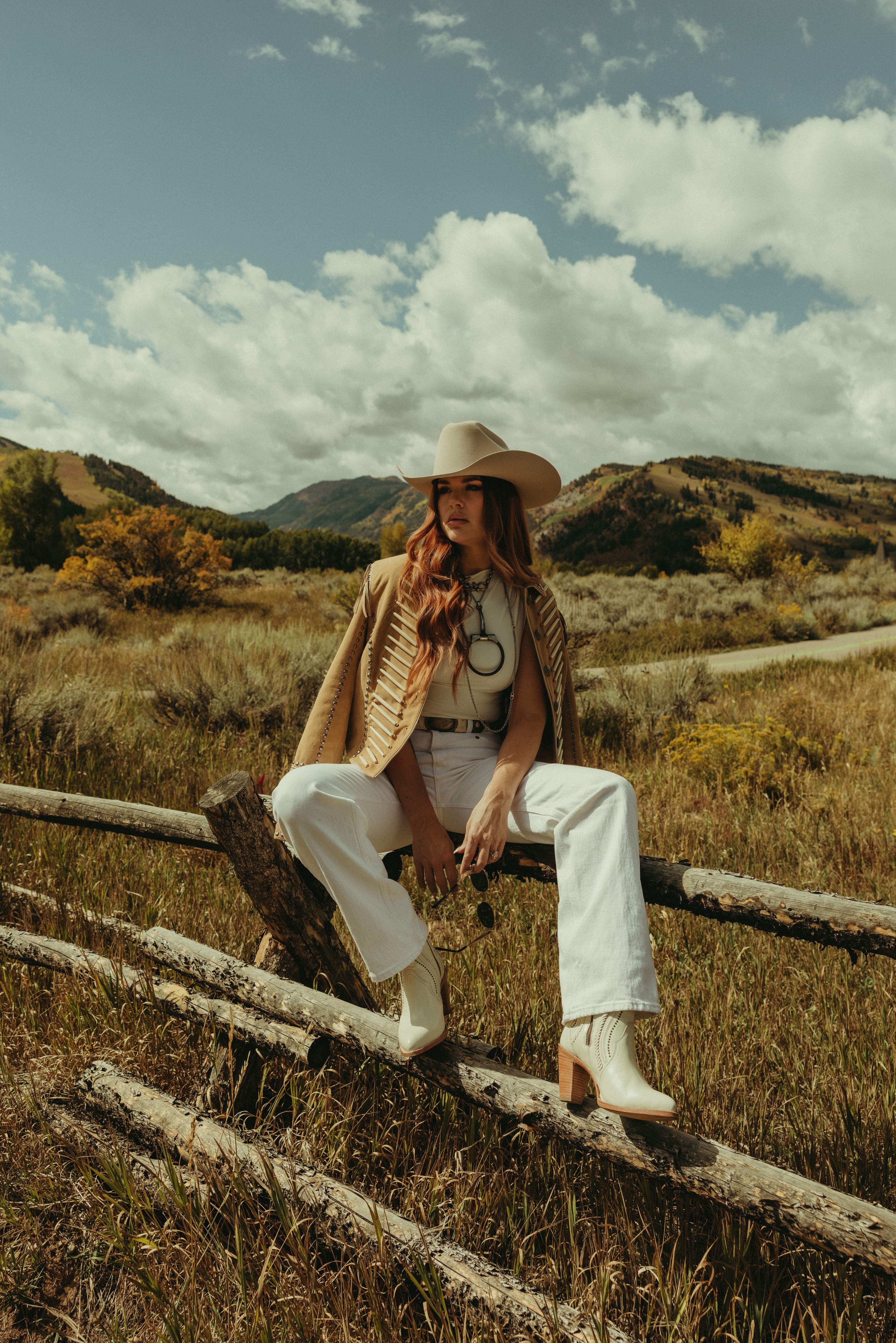 Woman on wooden fence in mountain meadow
