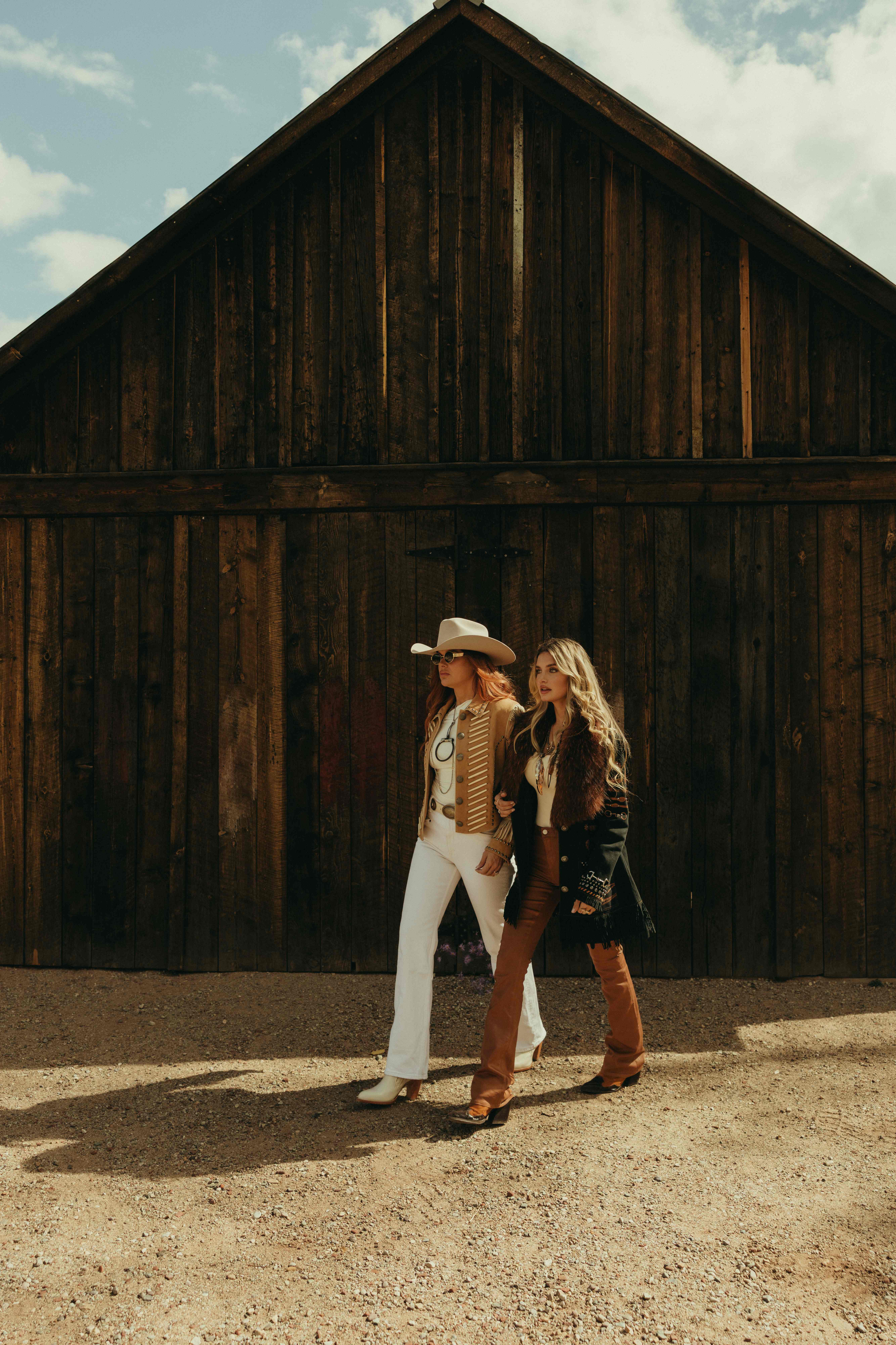 Two women walking in front of barn