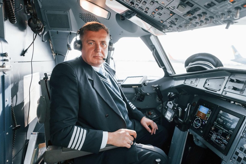 An airline captain seated at the controls of a commercial jet.
