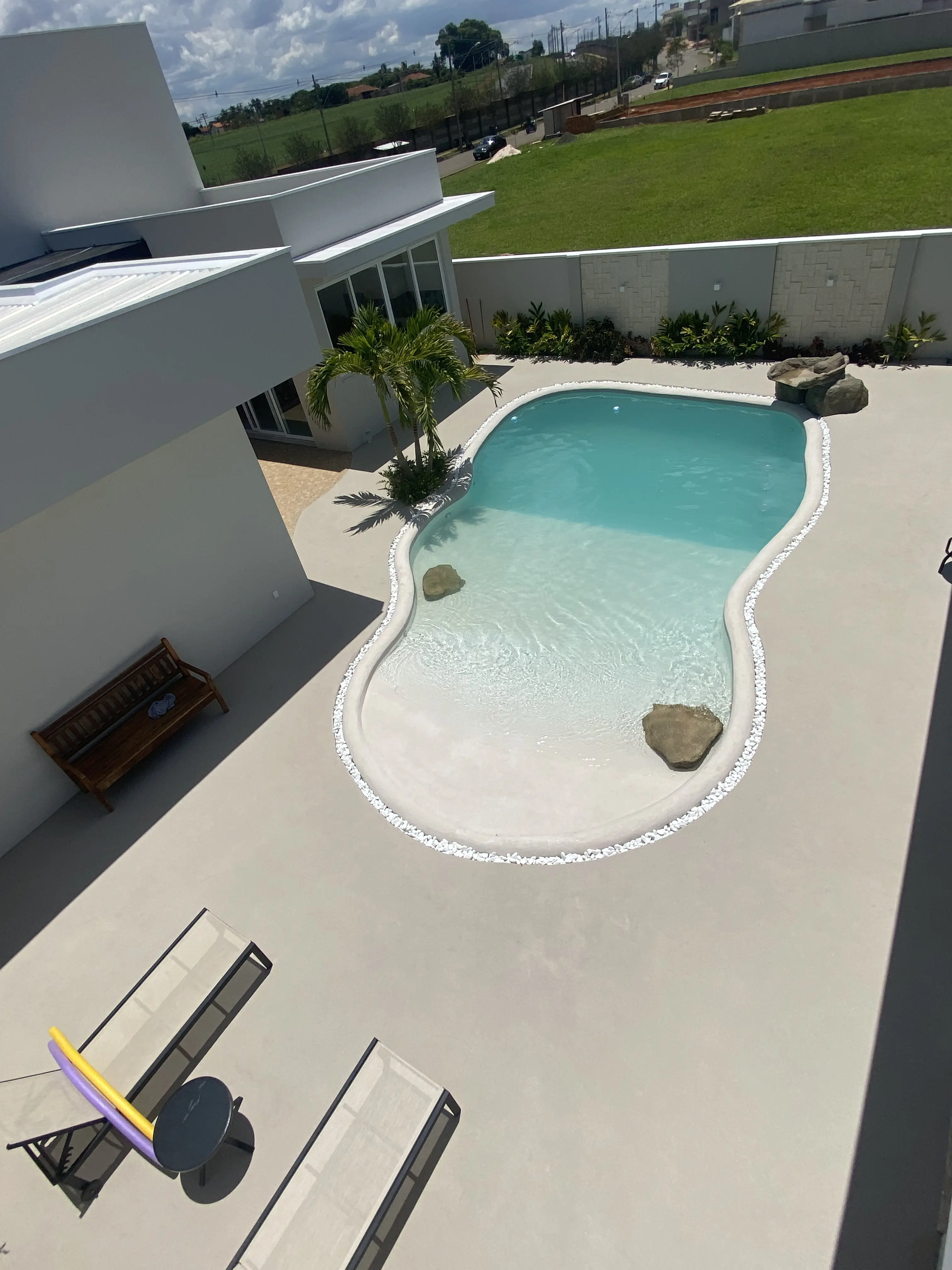 Piscina minimalista com formato biomorfo