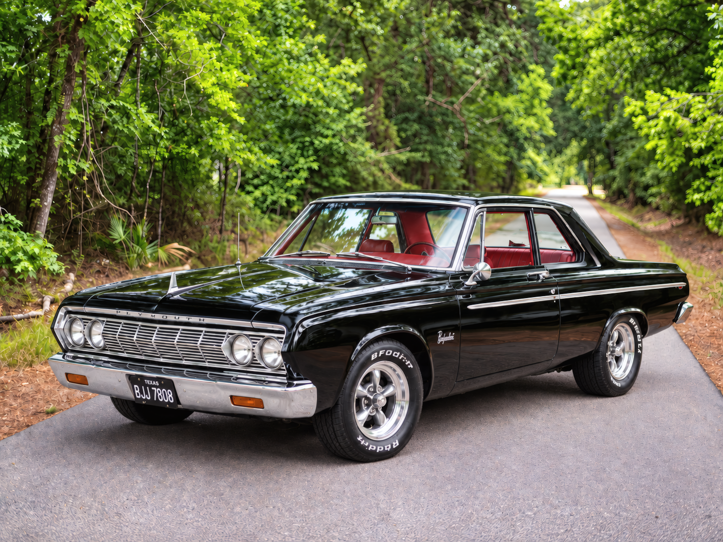 Plymouth Belvedere preto em uma estrada arborizada