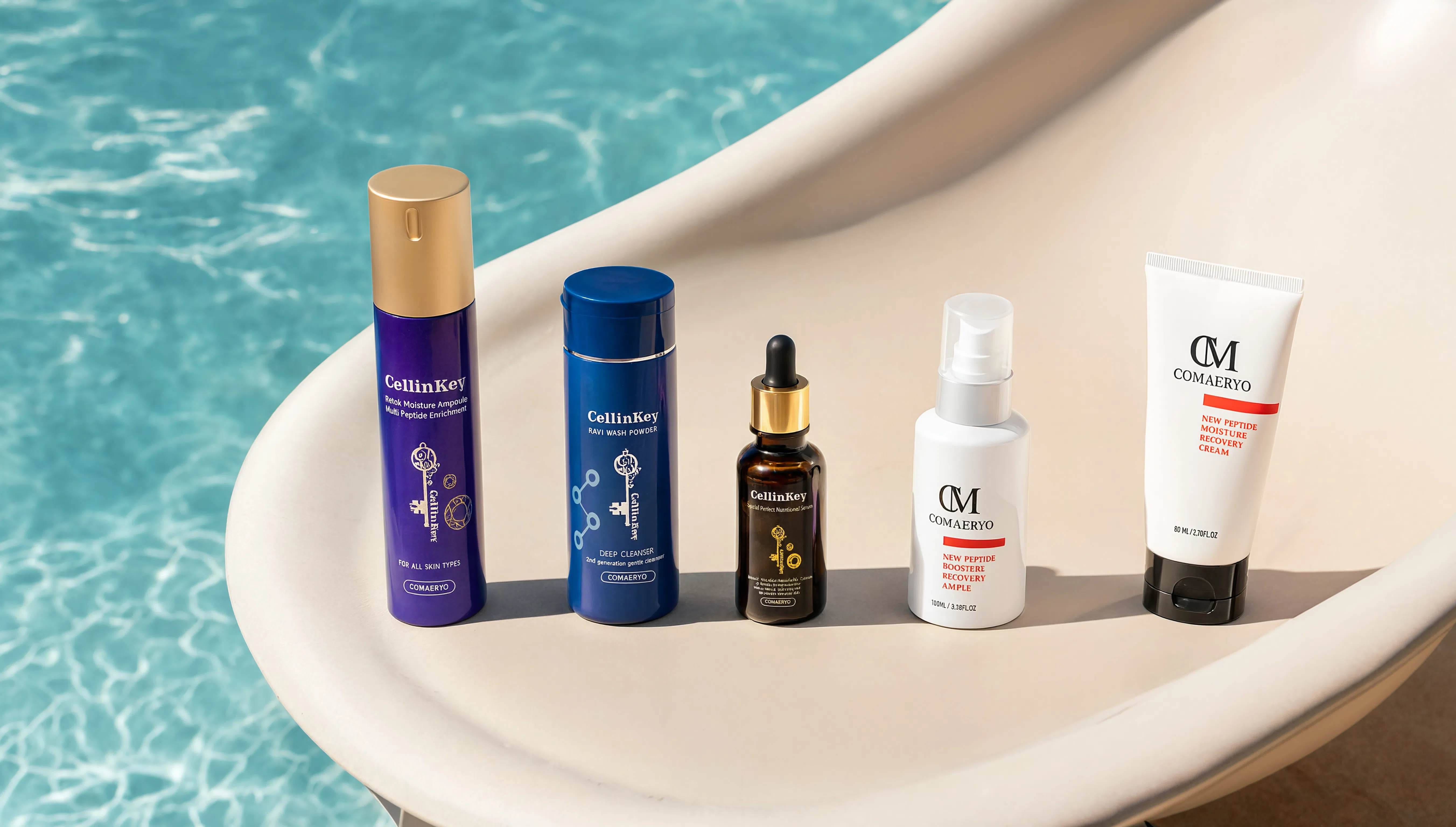 CellinKey and Comaeryo skincare products arranged on a cream poolside lounger beside turquoise water.