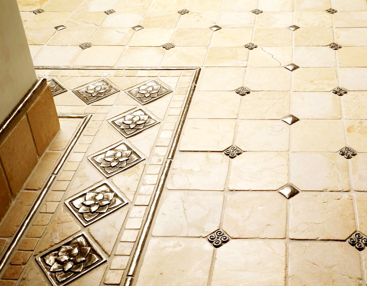 Ornate floor tile with decorative brass inlaid pattern, cream and beige tones with geometric design