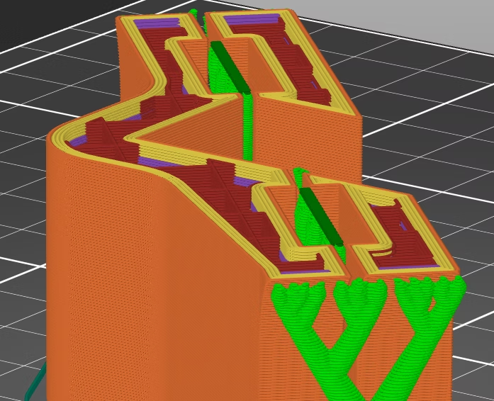 Slicer software showing toolpaths for a 3D printed jig — the orange, yellow and green layers visible before printing begins