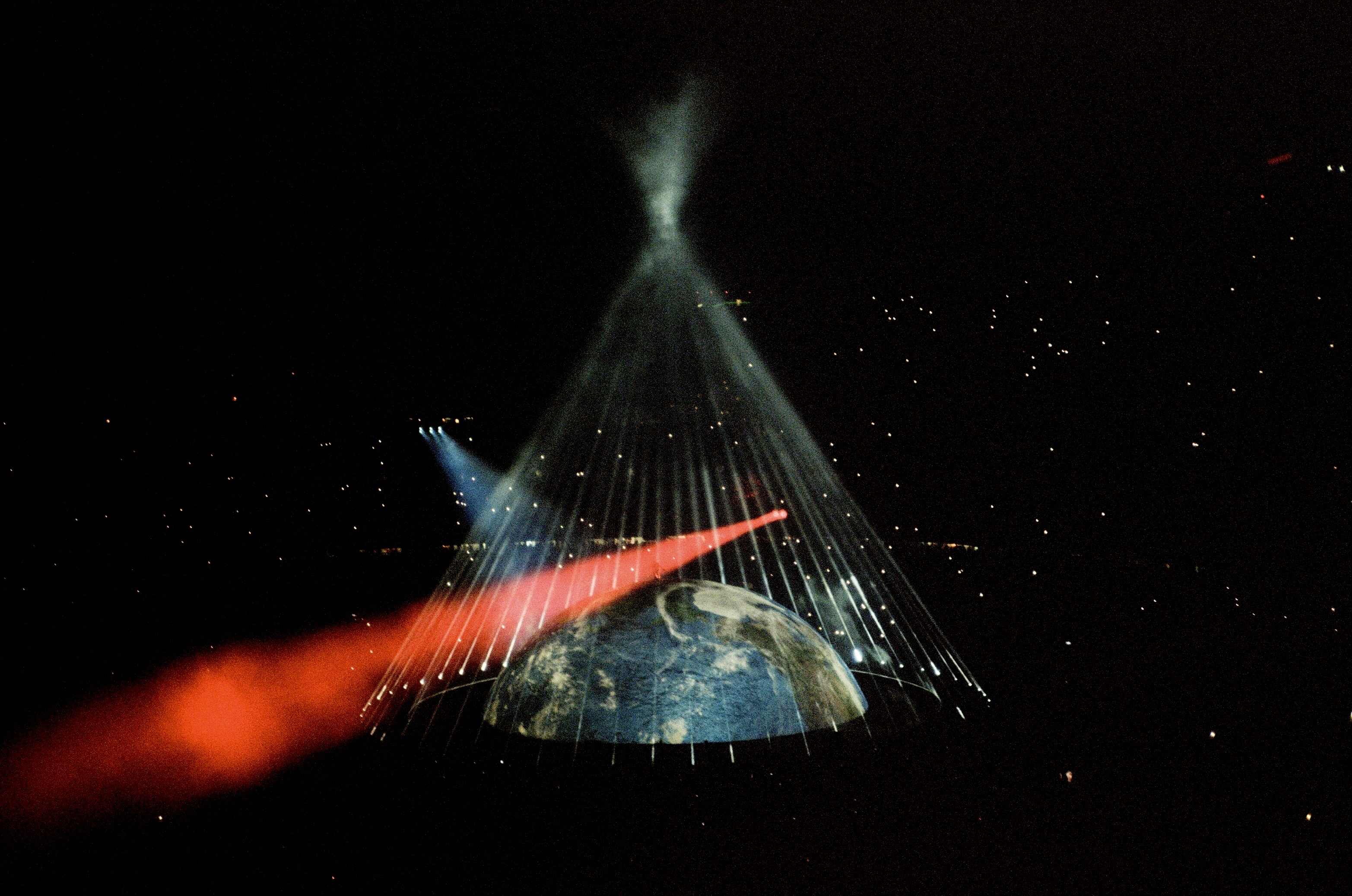 Earth dome with radiating strings of light forming a cone shape and a red beam crossing the frame