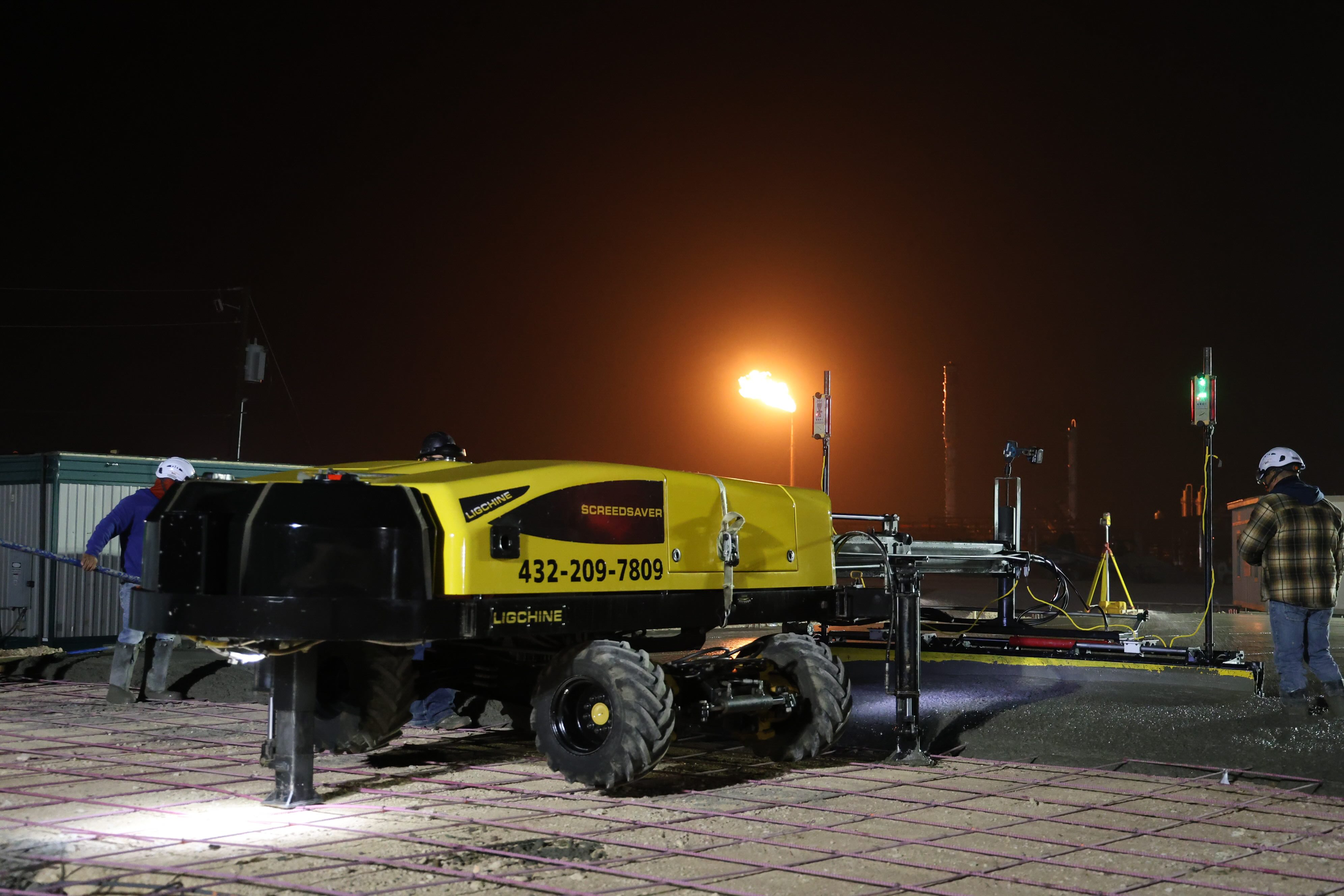 Commercial site preparation with mobile light tower at night