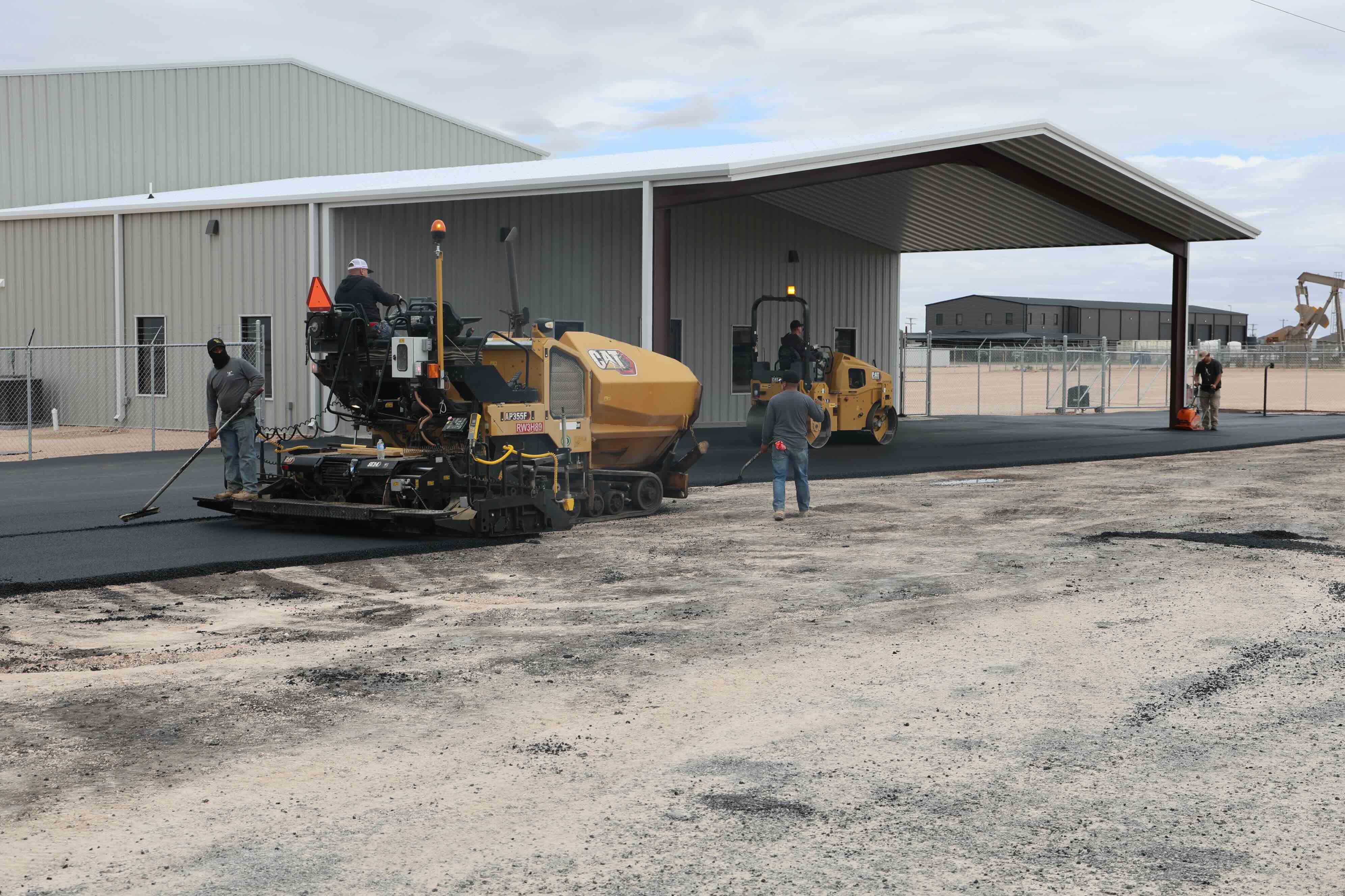 Asphalt paving and compaction equipment on commercial site preparation project