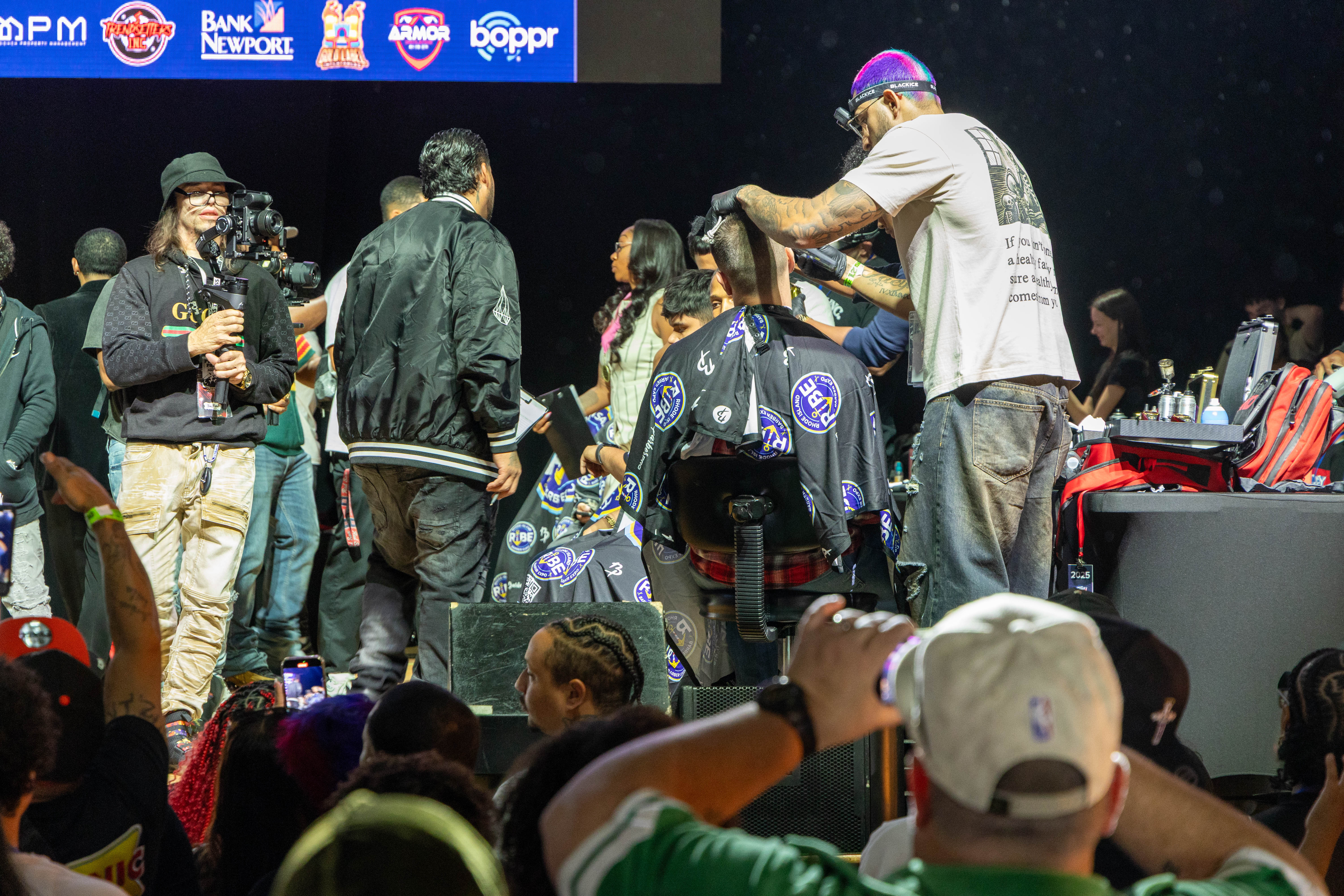 Barber working on client during competition