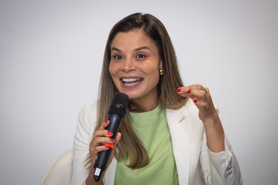 Painel com 5 pessoas, logos de patrocinadores ao fundo