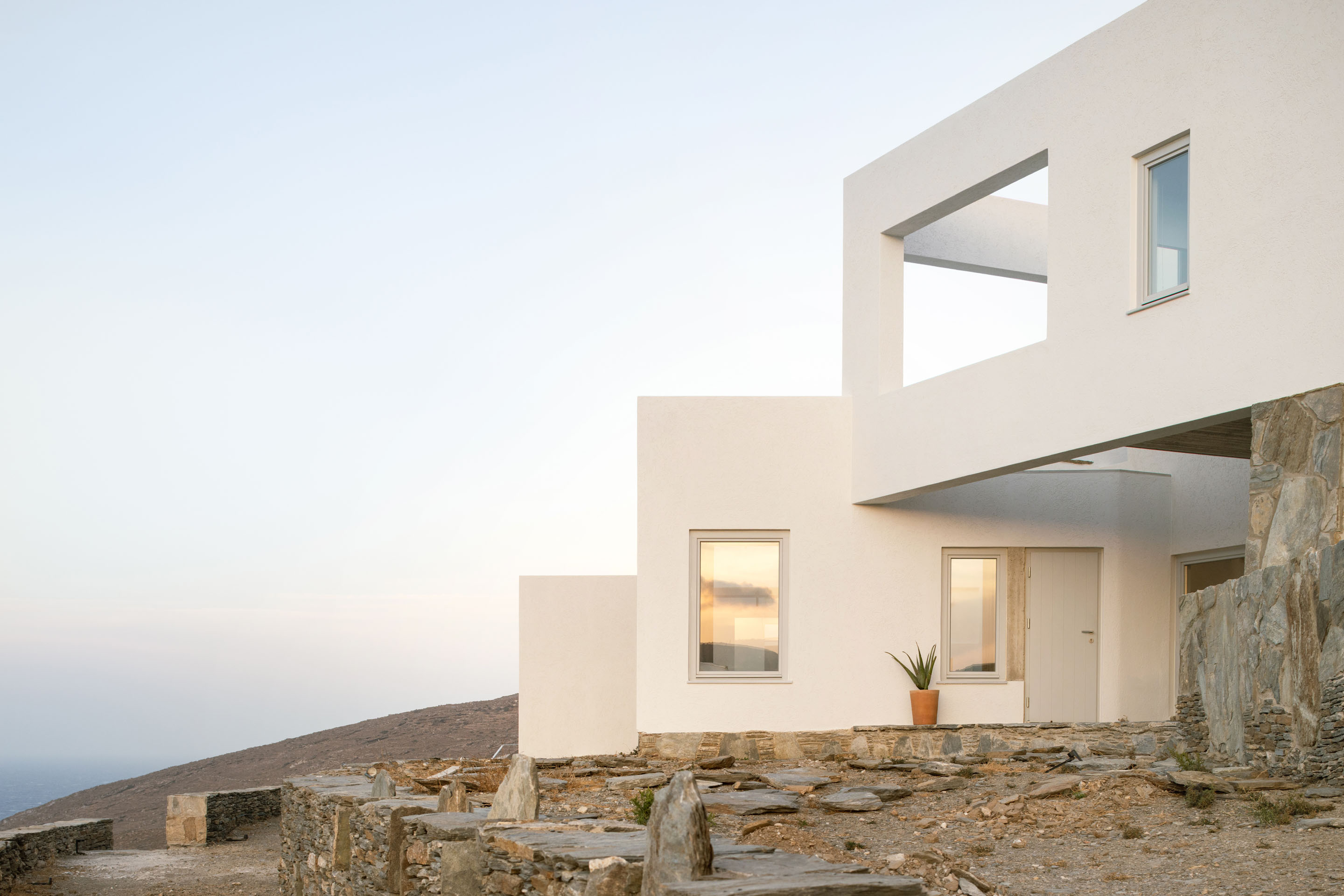 Exterior detail showing white cubic forms and stone landscape