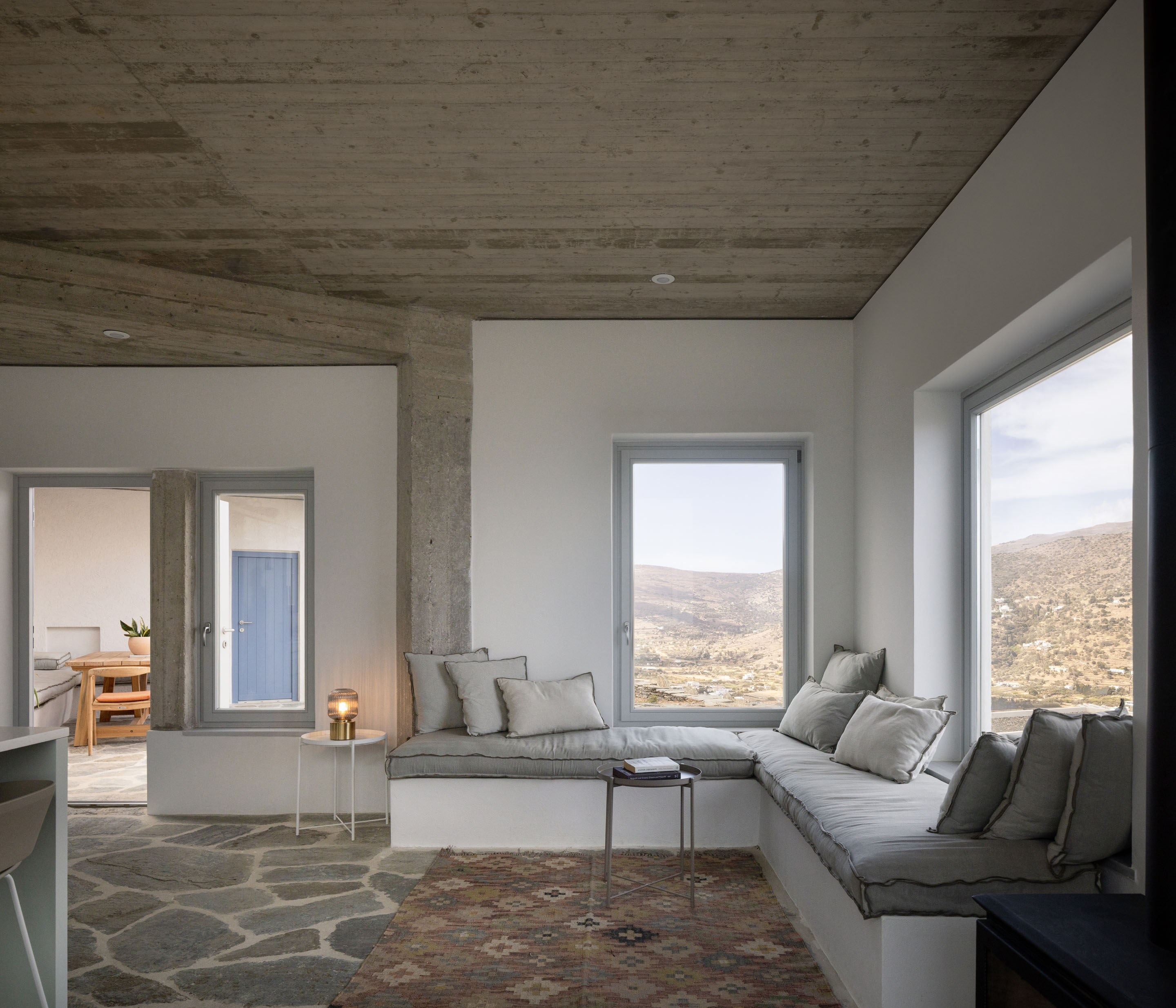 Interior living room with L-shaped built-in sofa and mountain views