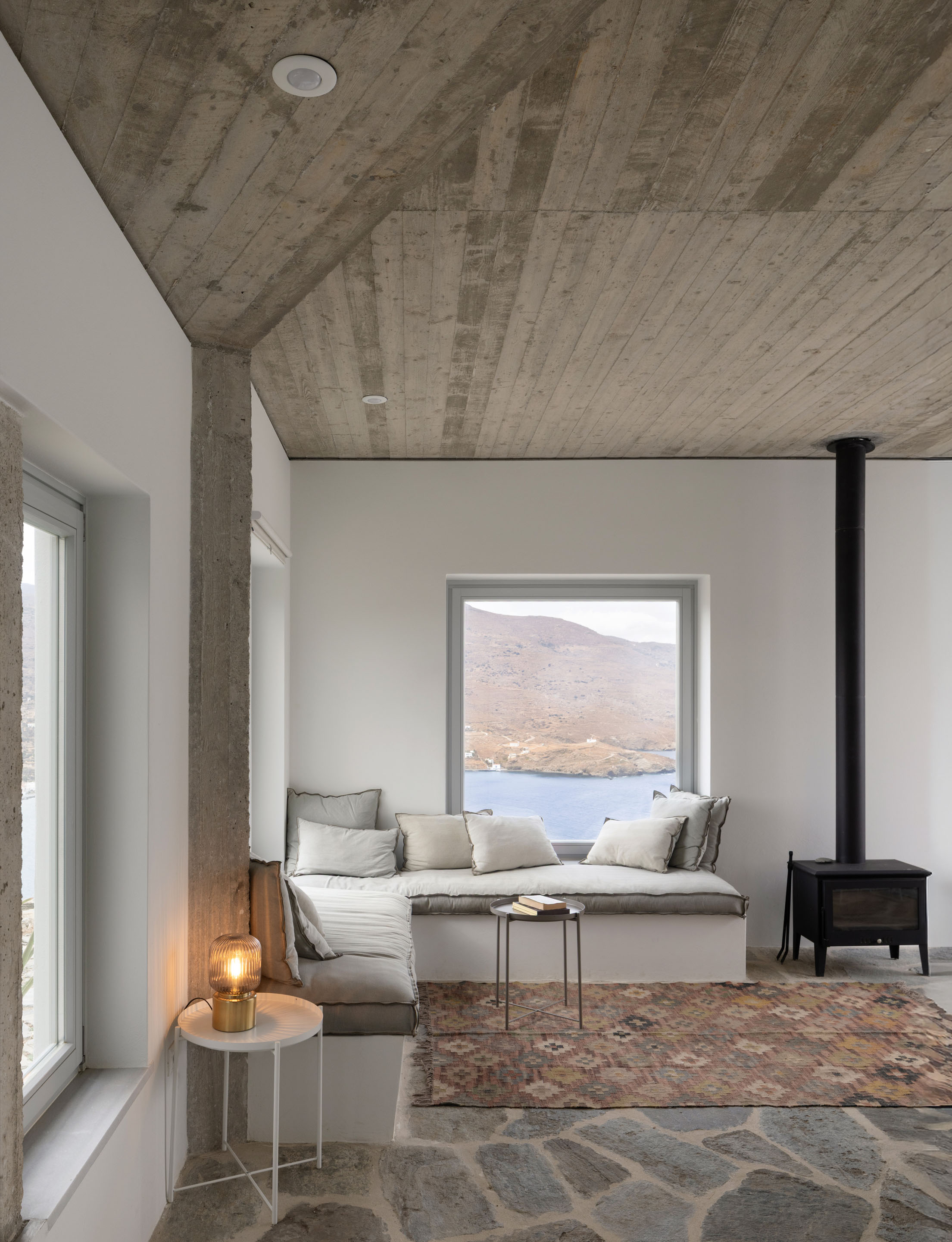 Interior living space with concrete ceiling, built-in daybed and sea view window