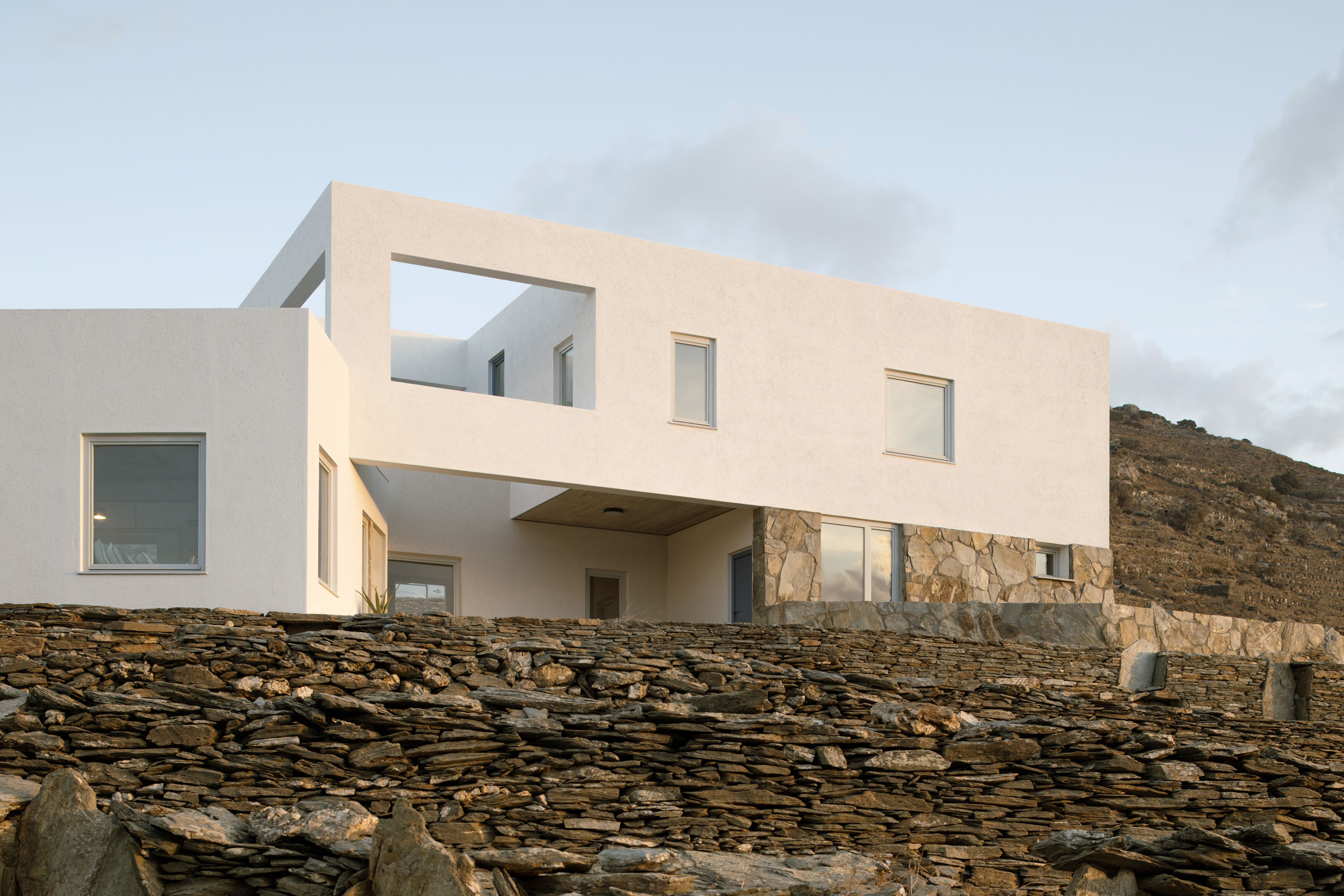 Two-story house detail with stone wall base