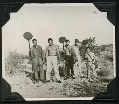 A group of men standing with their mine-detection equipment.