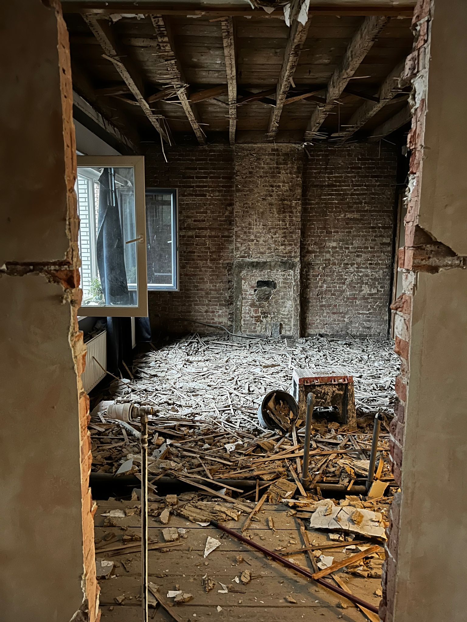 Sloopfase interieur met puin en kale bakstenen muren