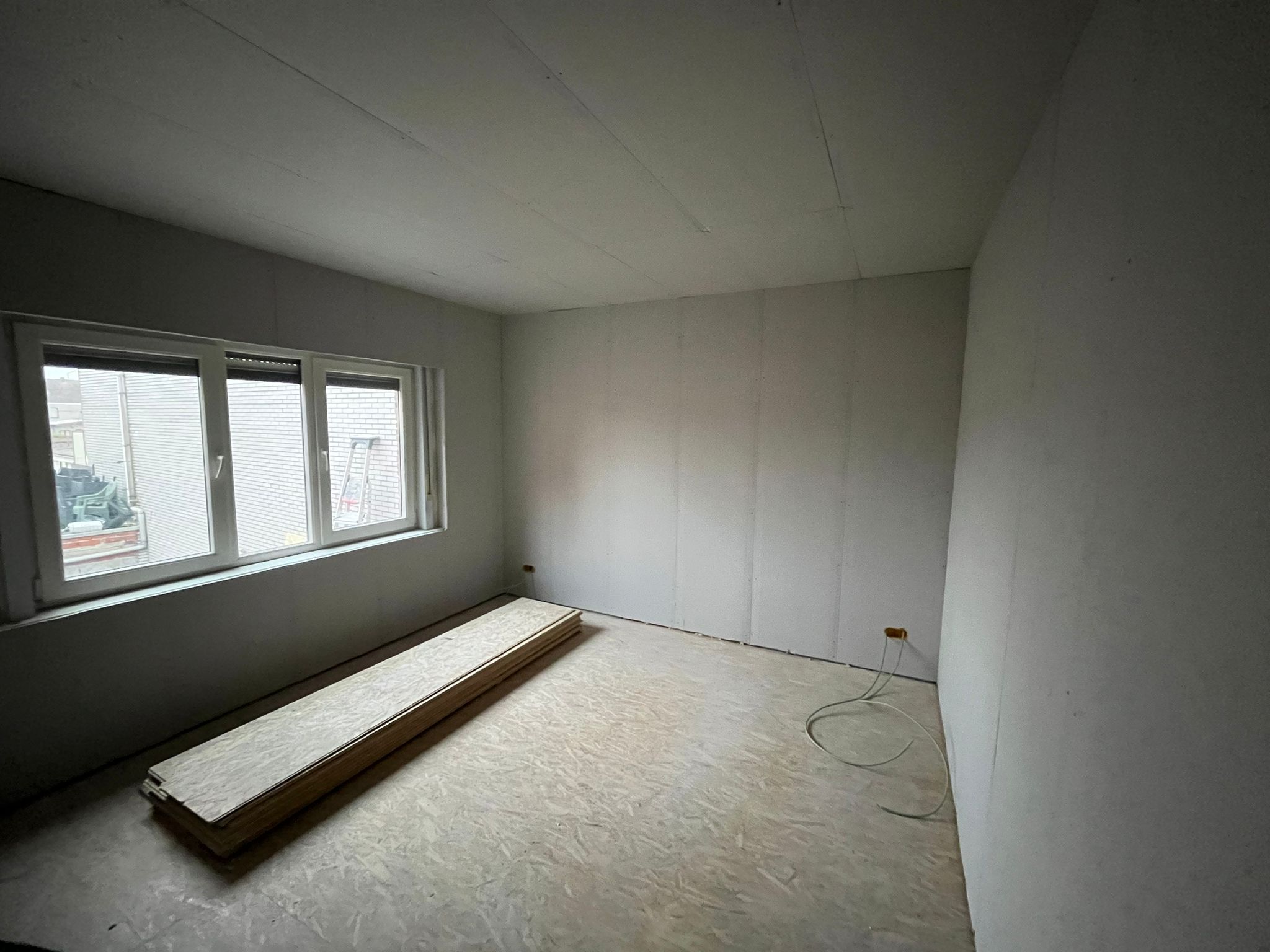 Witte kamer klaar voor afwerking met vloerplanken