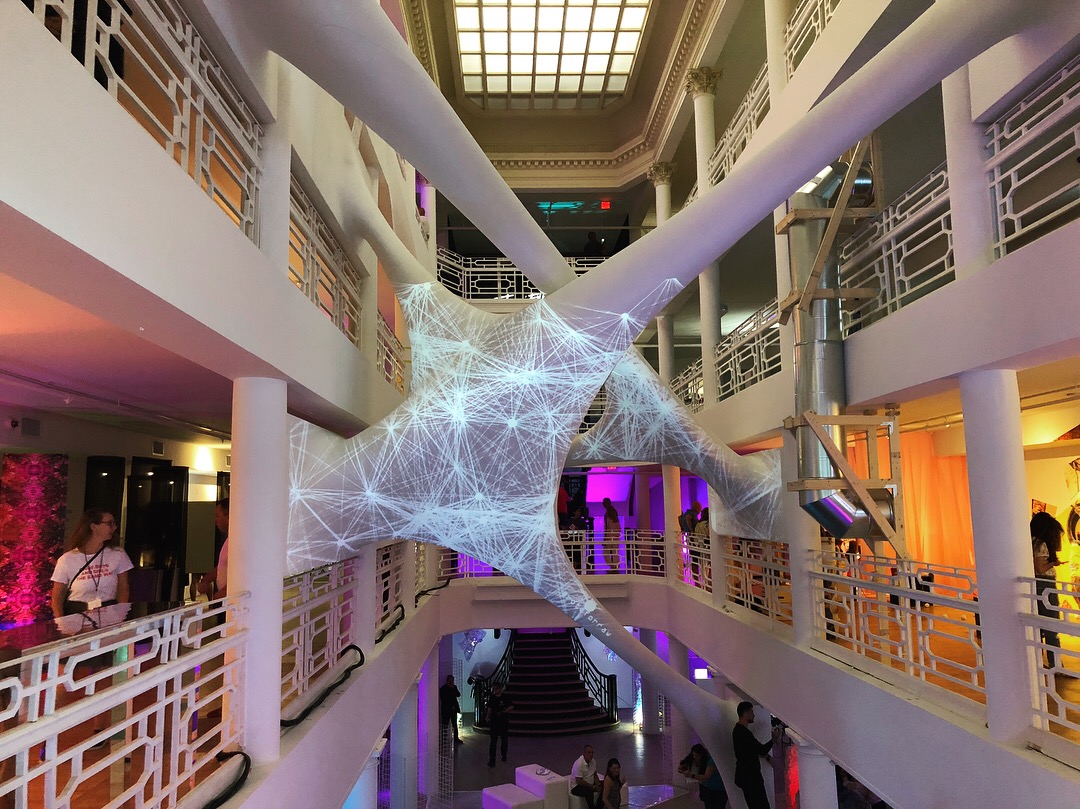 The Rote installation showing network-like patterns projected onto the white sculptural form spanning multiple floors