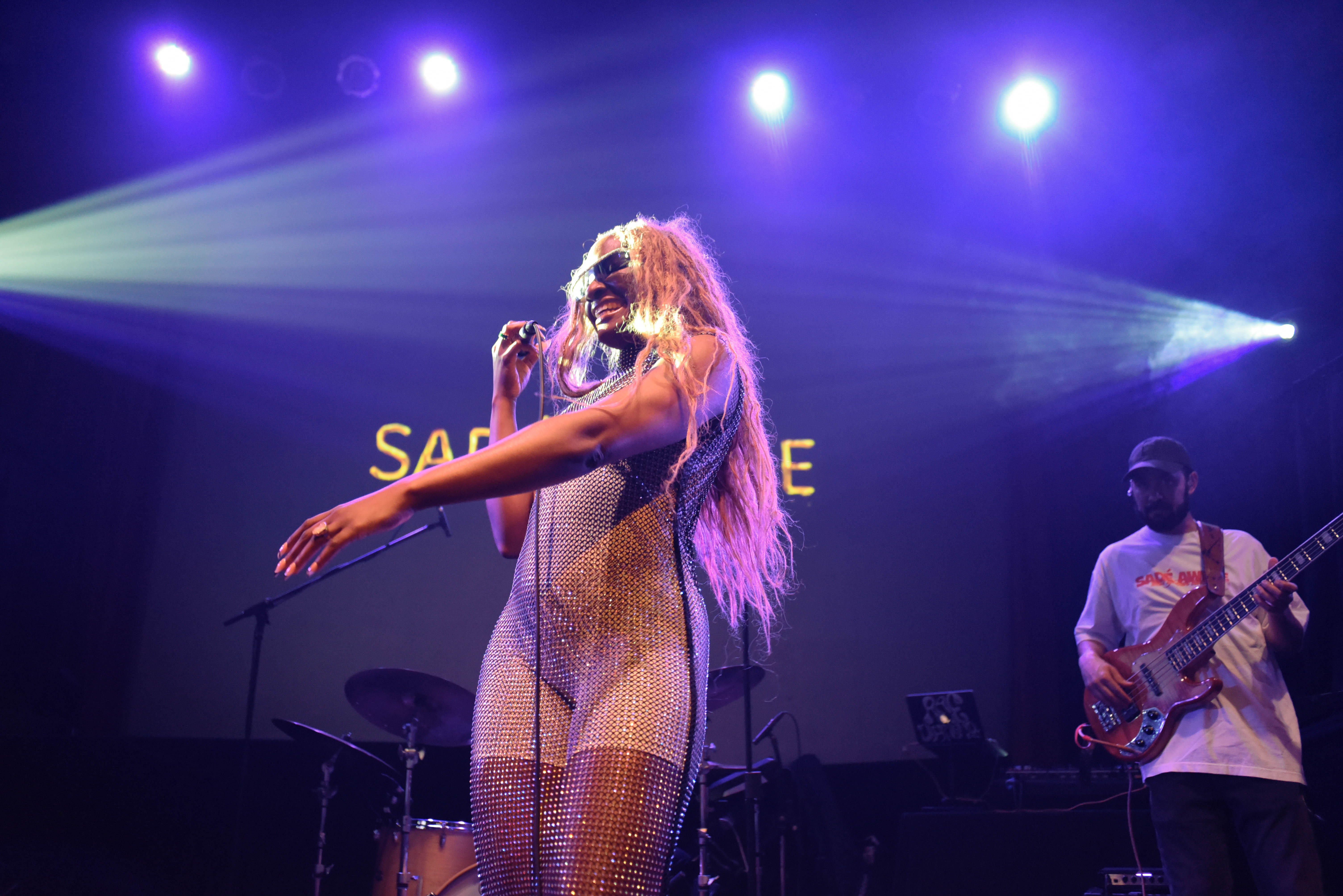 Sadé performing on stage with band