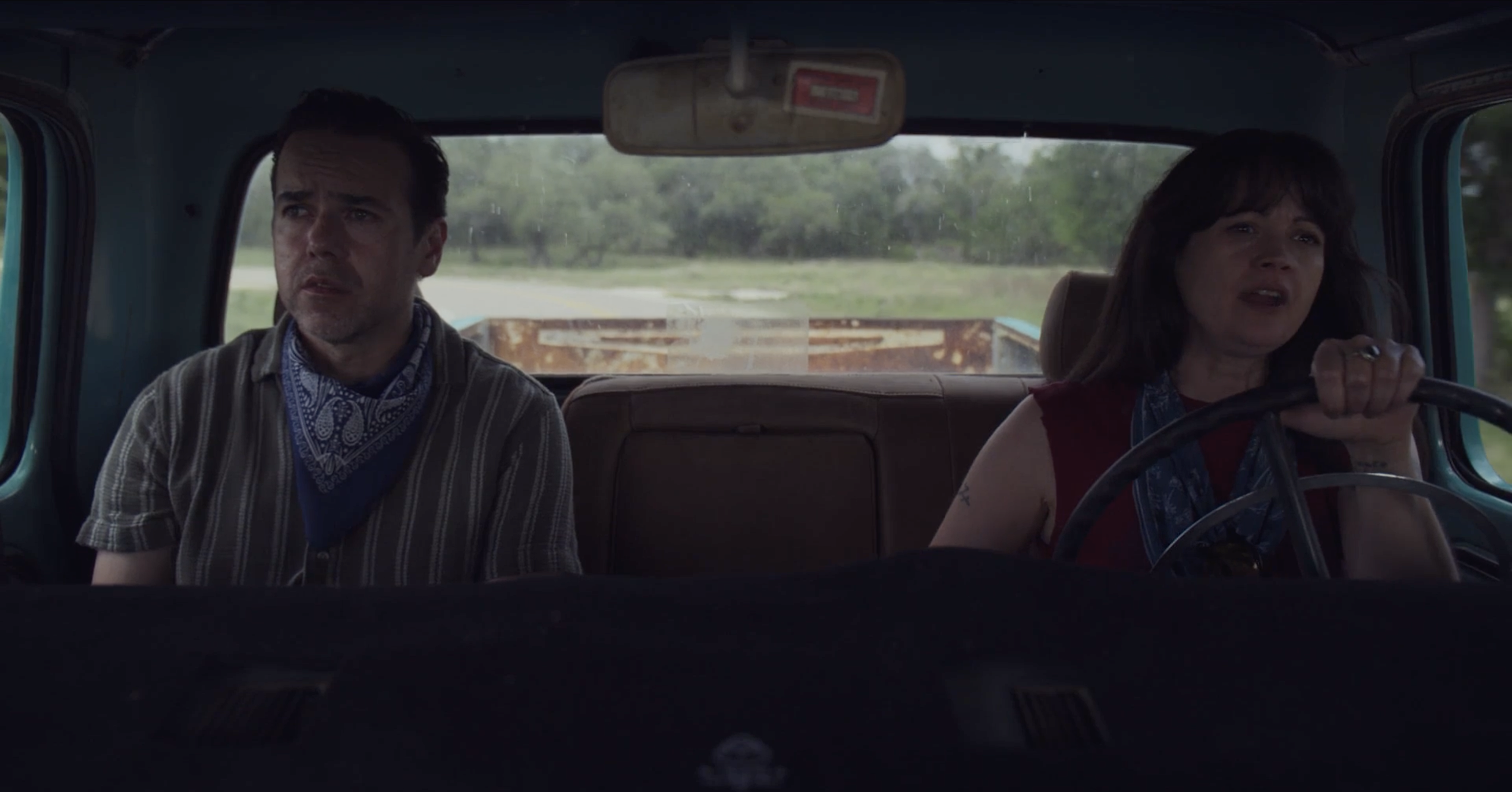 Charlie and Dee riding together in a vintage truck